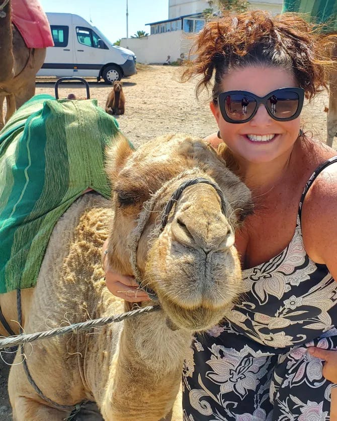 Travel advisor posing with a camel