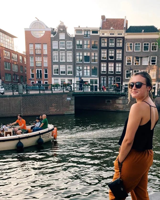 Posing for a photo by the canal in Amsterdam