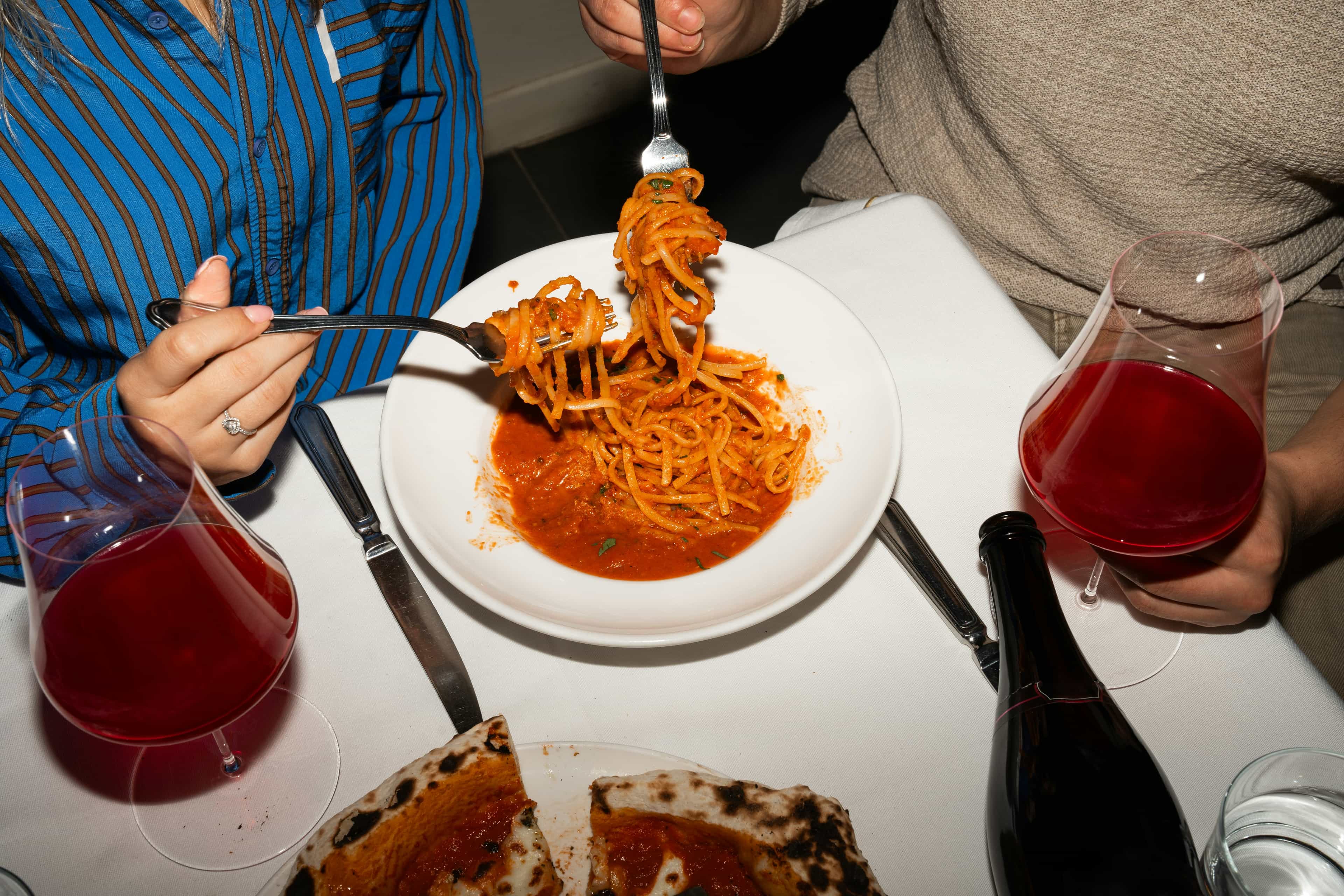 aerial view of people enjoying pizza, pasta, and wine
