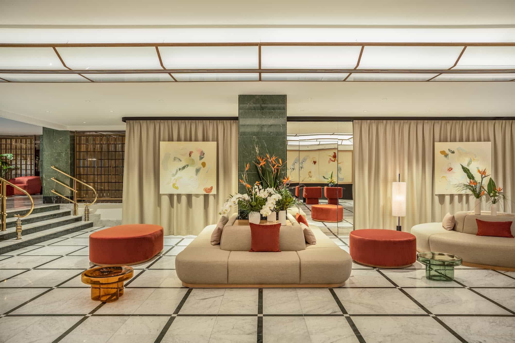 Hotel lobby area with green pillars, cream lounge seating and orange decoration
