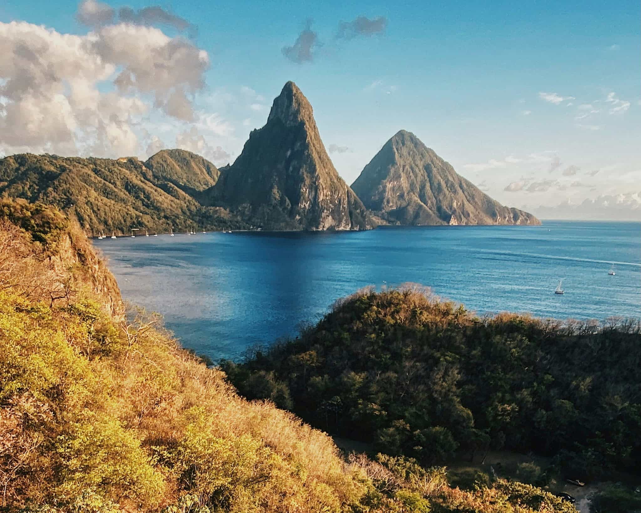 mountainous island peaks next to ocean during day