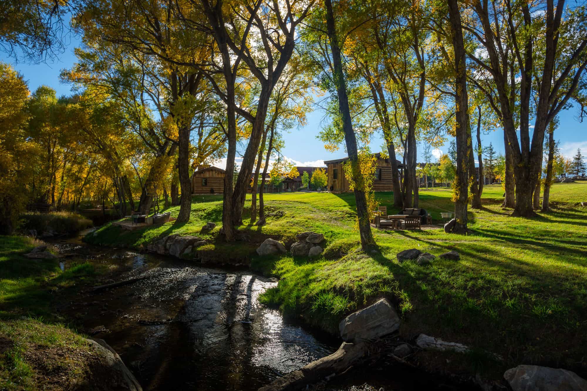 wooden cabins on a green expanse on a sunny day