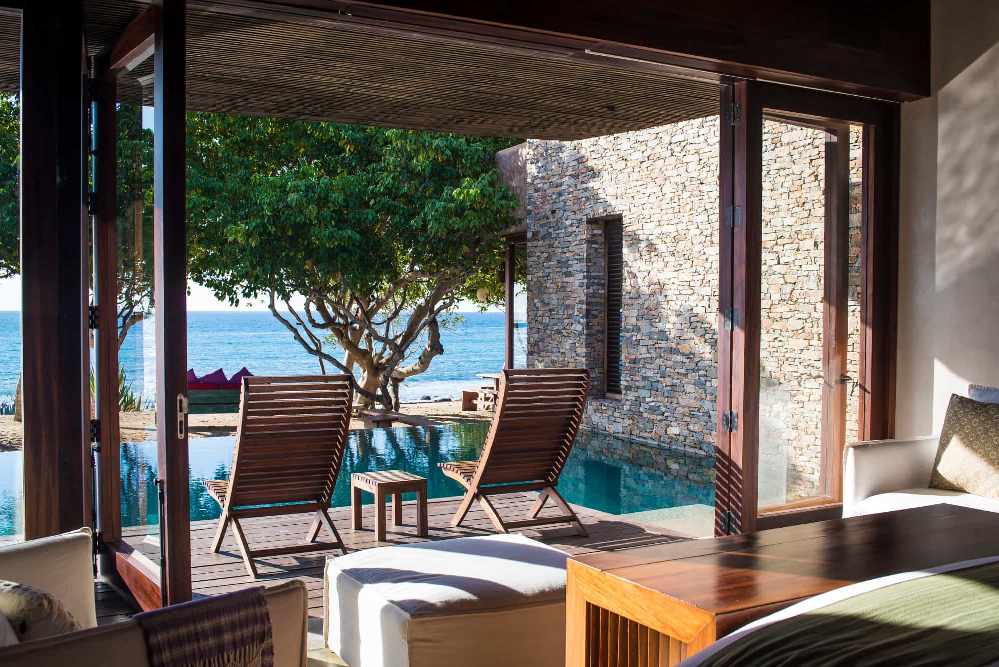 an oceanfront bedroom with an infinity pool on an outdoor patio