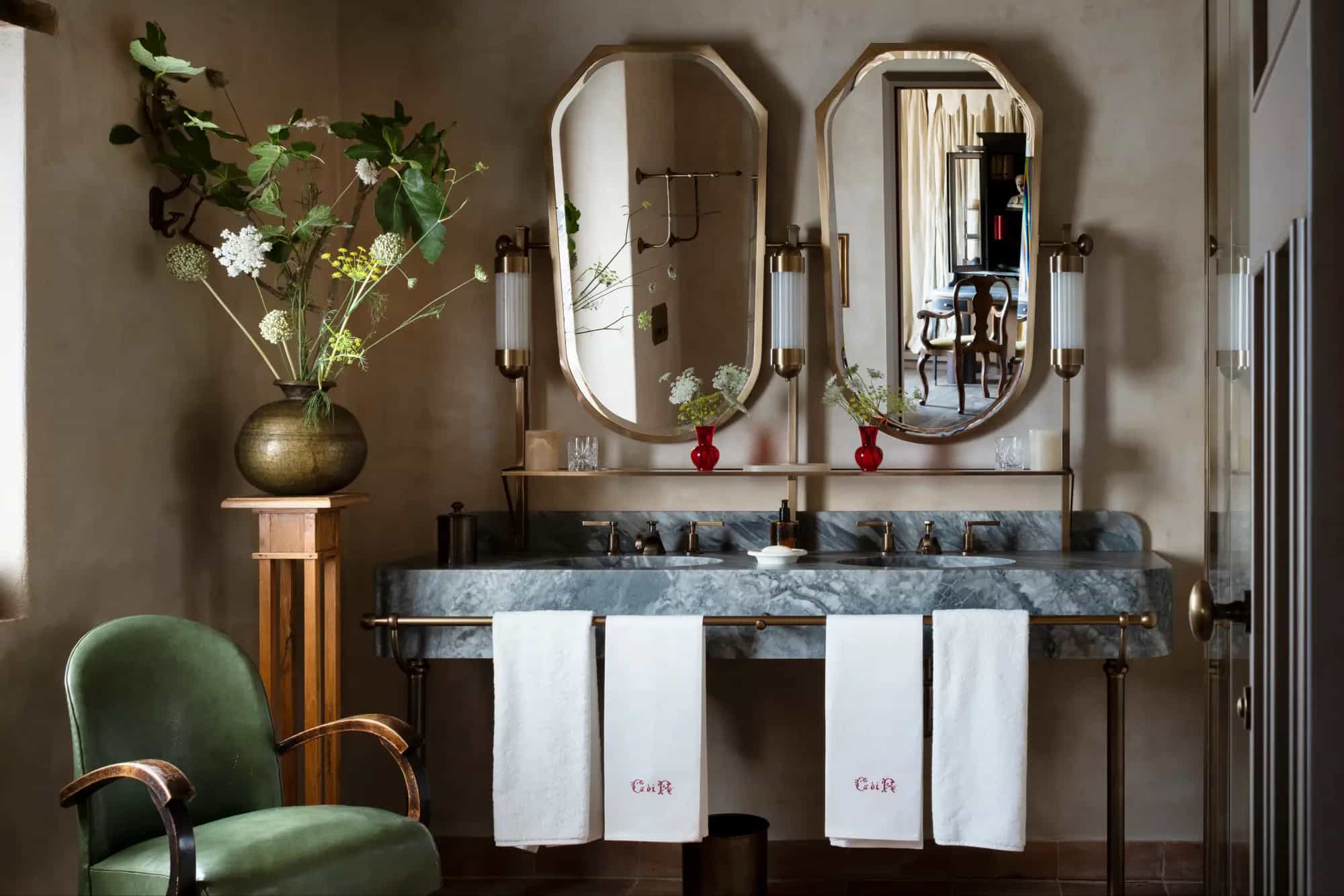 a luxe bathroom with a dual-sink marble vanity and two mirrors