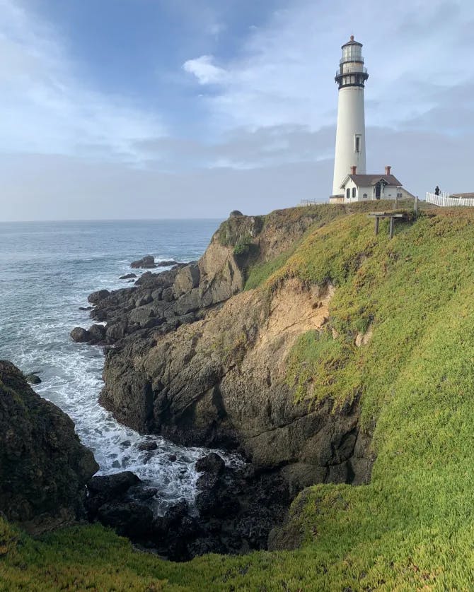 A lighthouse besides ocean.
