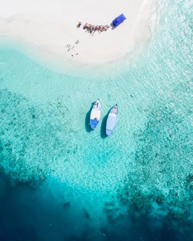 aerial view of two white boats in a turquoise sea