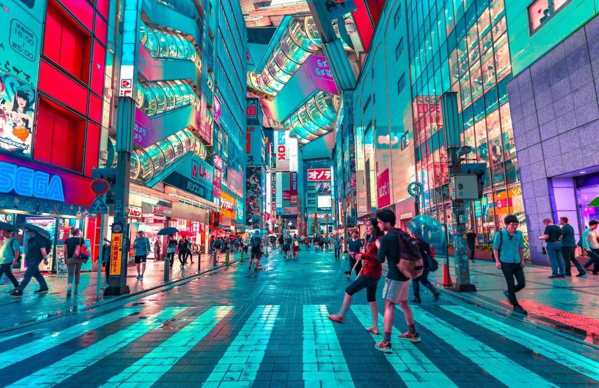 A view of the colorfully lit metropolis of Tokyo, with various people walking the streets. 