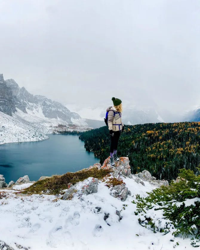 Travel advisor posing beside a lake and mountains covered with snow