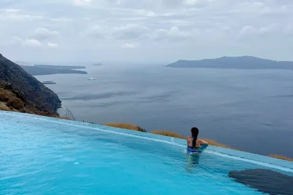 A person at the edge of a pool looking out on a large body of water