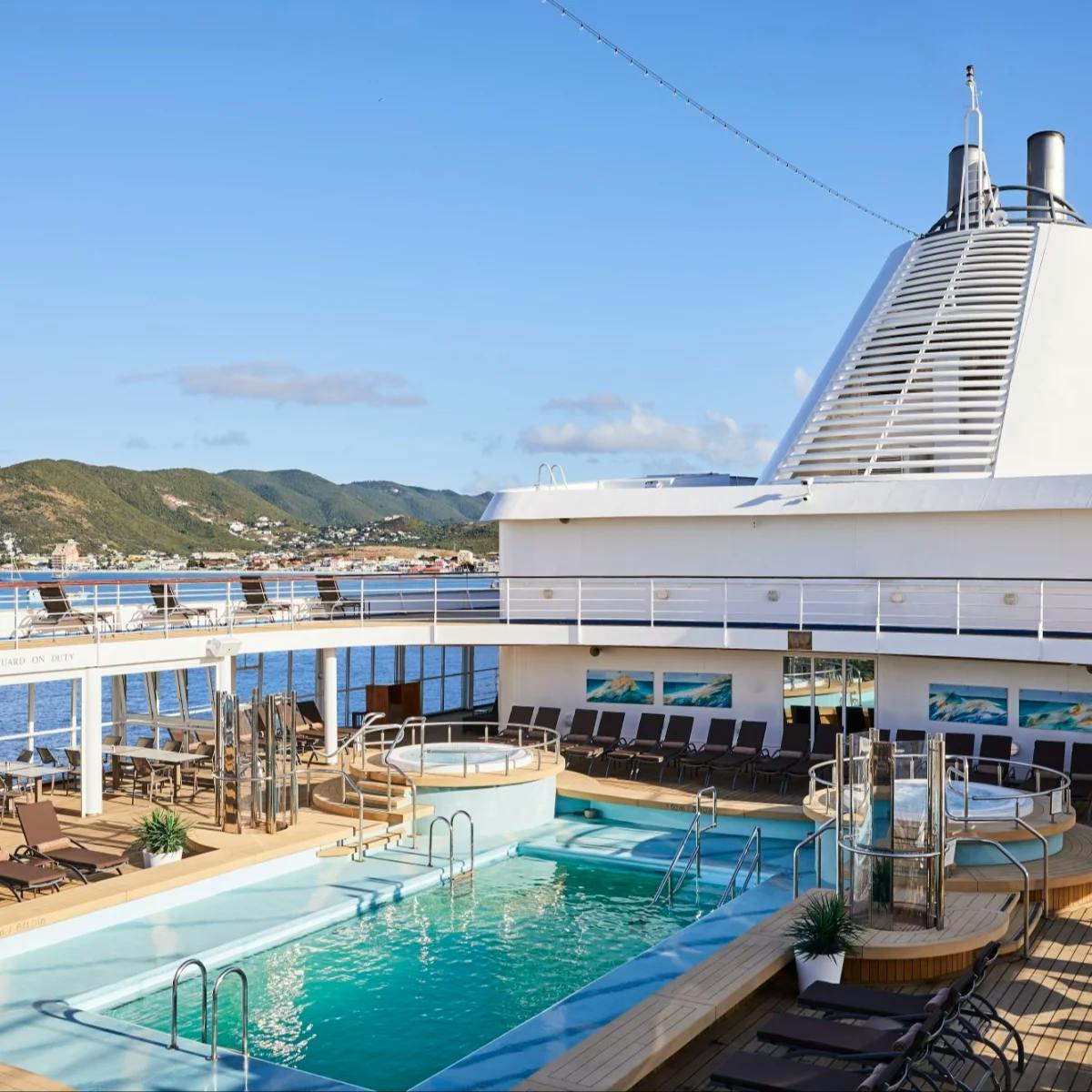 a cruise pool deck with lounge chairs