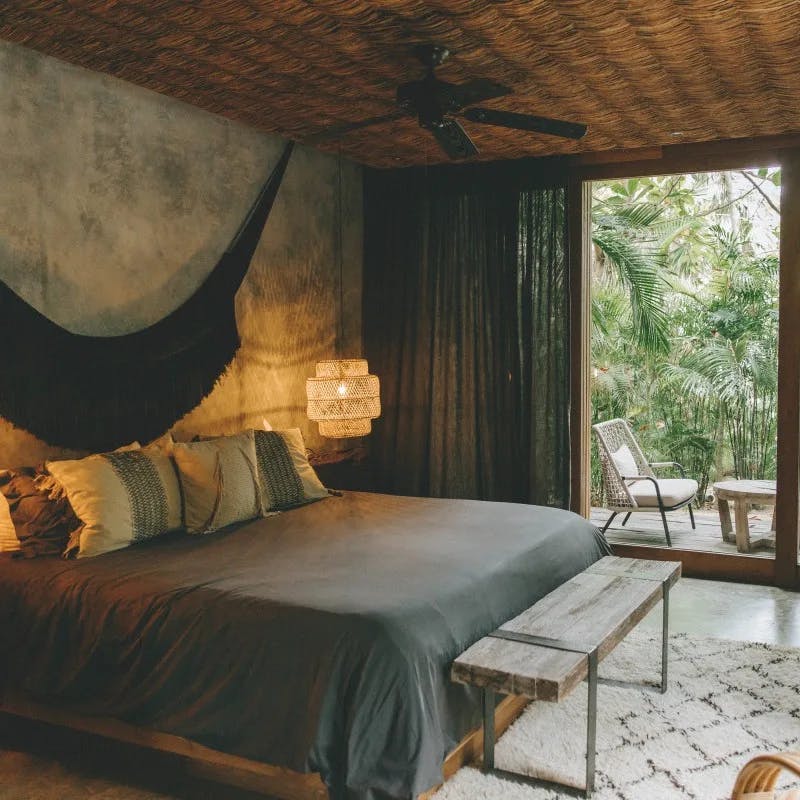a chic jungle hotel room with gray and charcoal-colored decor