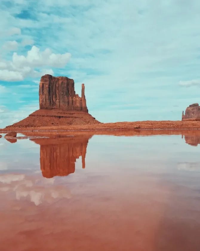 Red-rock formation on a reflective lake