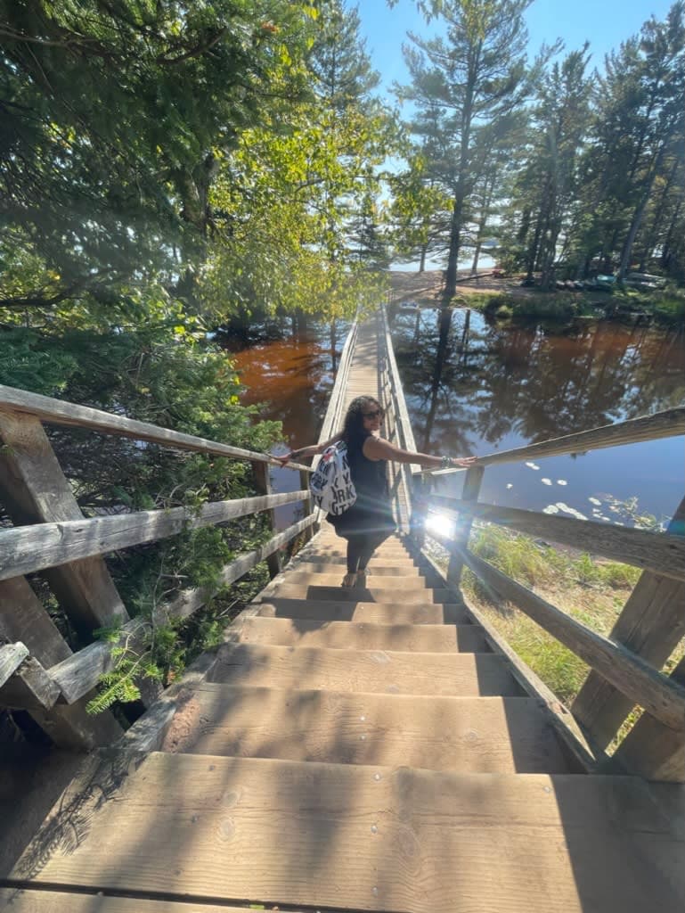Picture of Lydia posing on a narrow outdoor staircase surrounded by water and trees