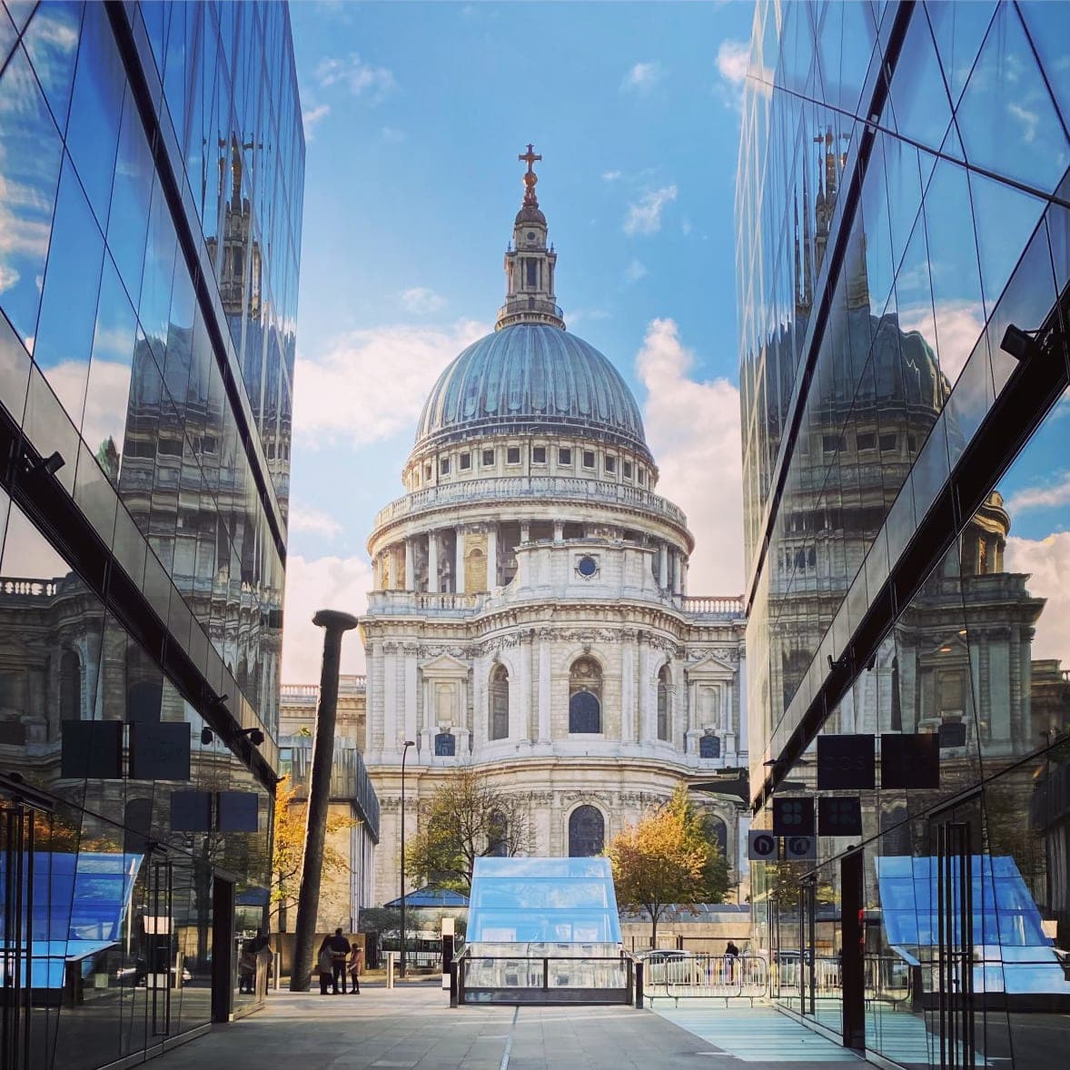 St. Paul's Cathedral seen from a street view in between two glass buildings on a clear day