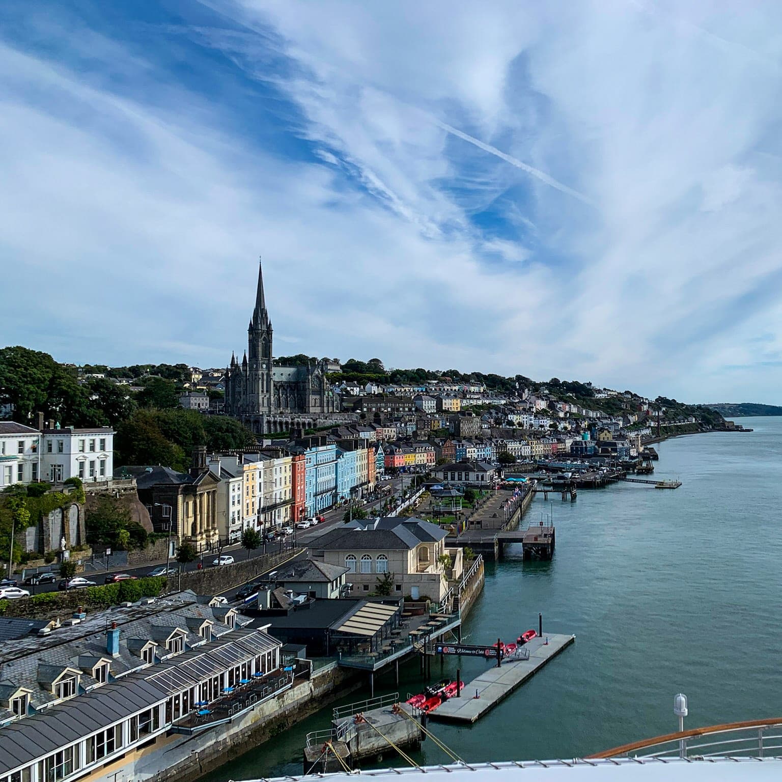 Beautiful aerial view of a coastal city with colorful buildings and a church spire rising above the rest on a sunny day