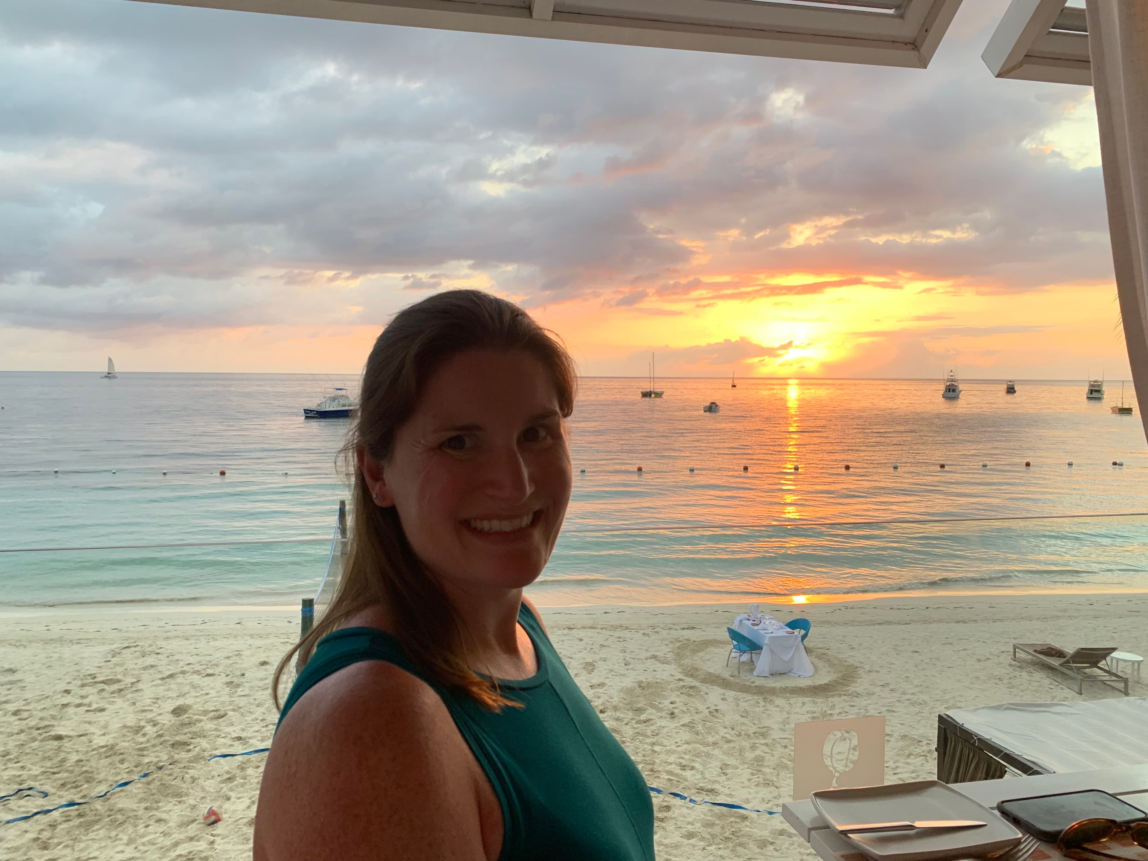 Travel advisor Erin standing by a beach at sunset
