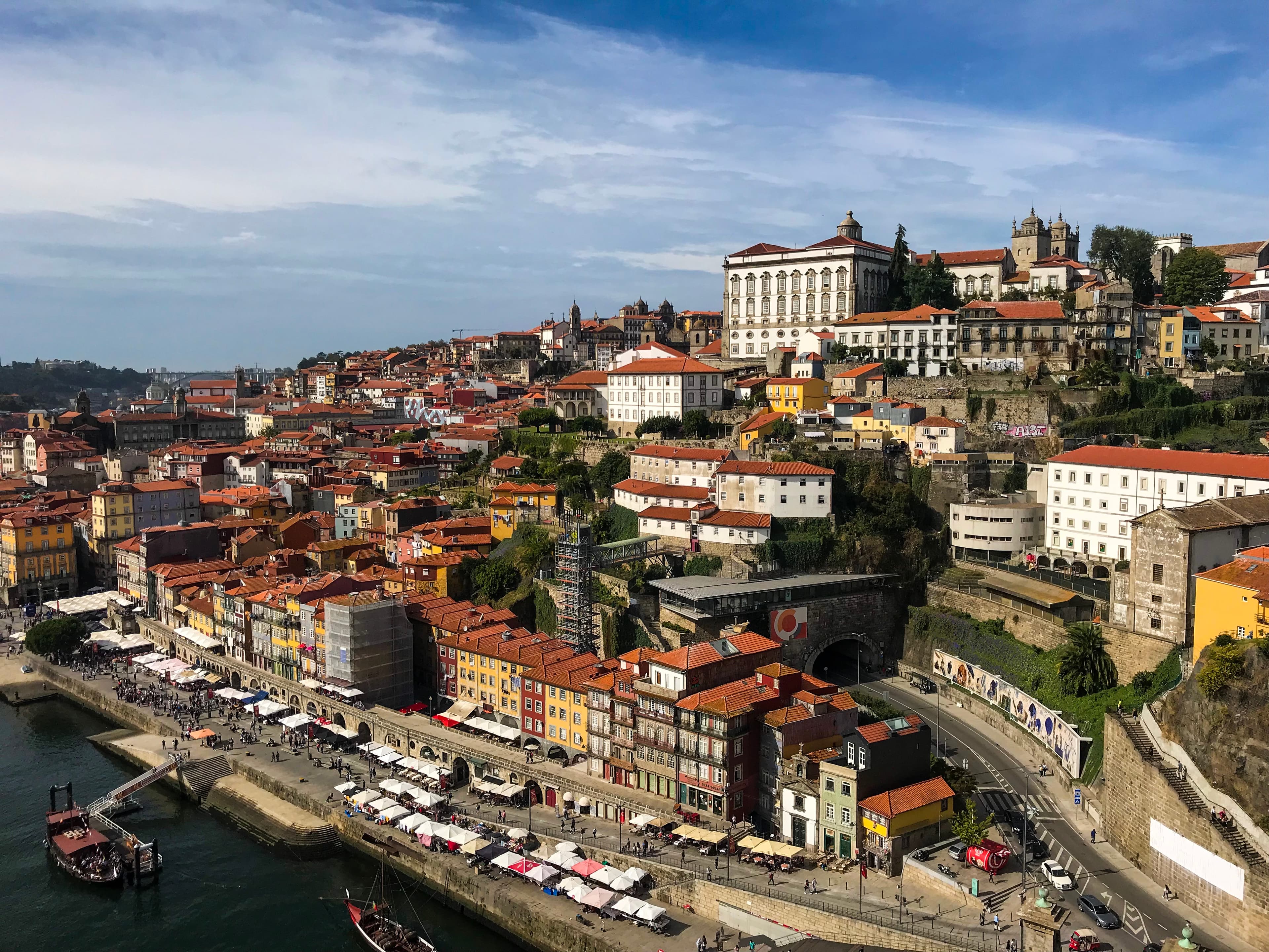 An aerial view of a picturesque town on a hillside with a body of water below.