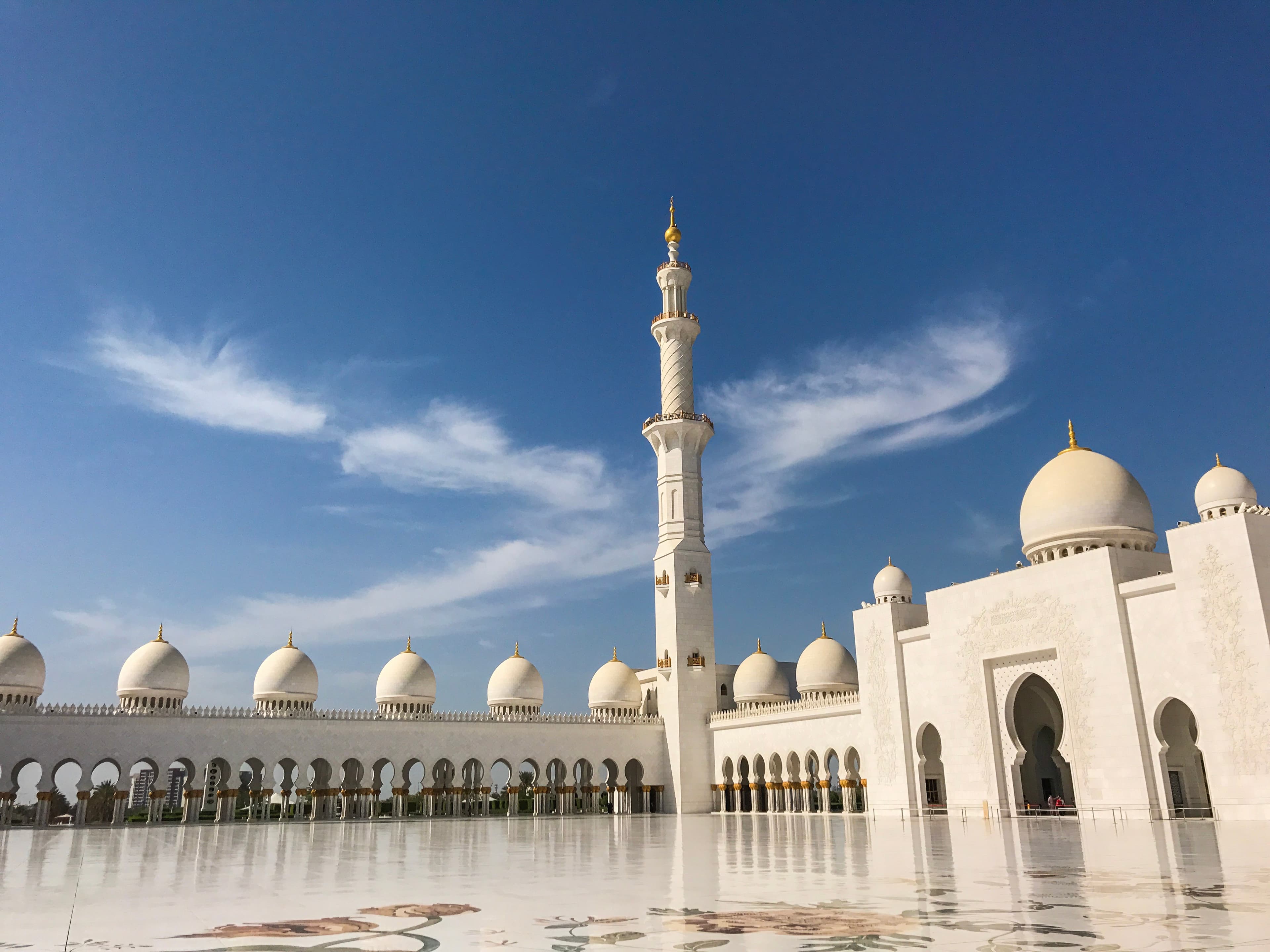 A beautiful white mosque and white esplanade on a sunny day.