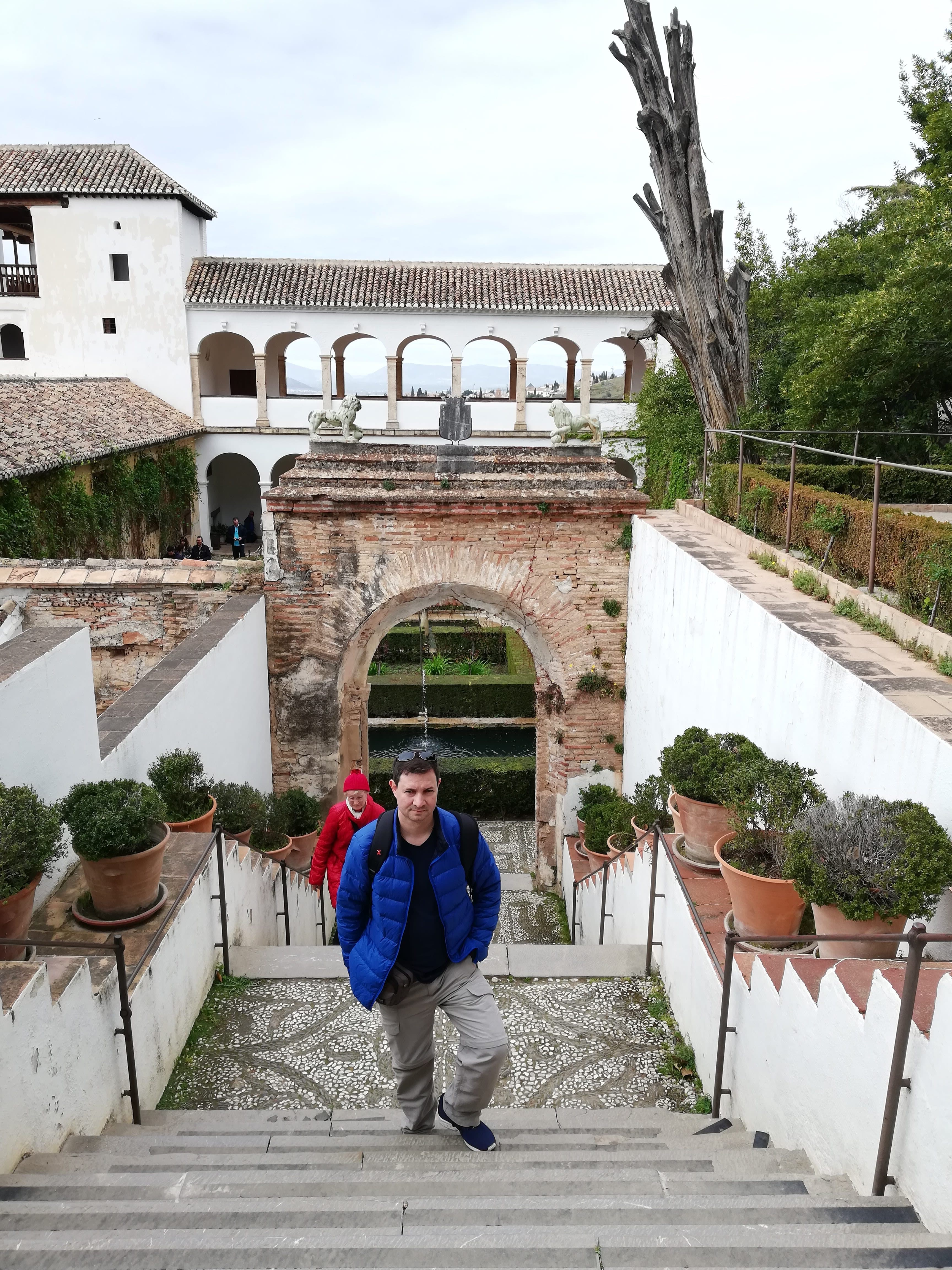 Advisor posing on a concrete staircase with buildings in the distance and foliage in the daytime. 