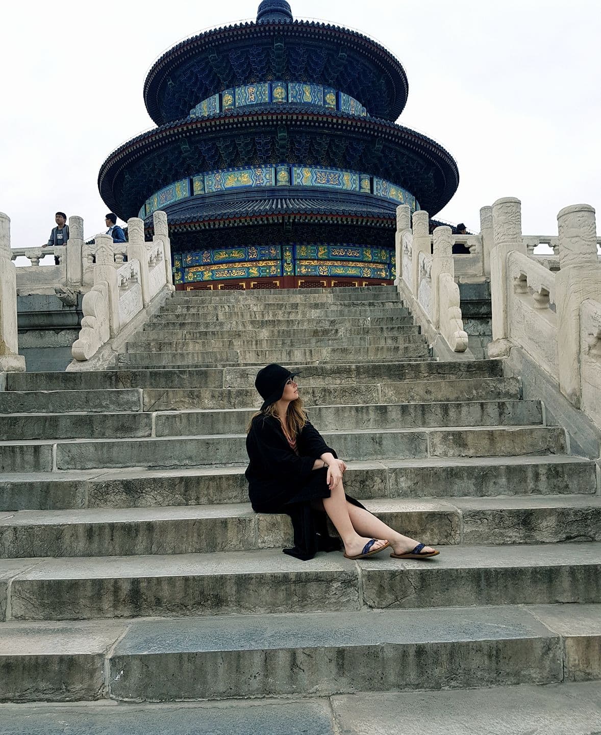 Advisor posing on a concrete staircase in China on a cloudy day. 