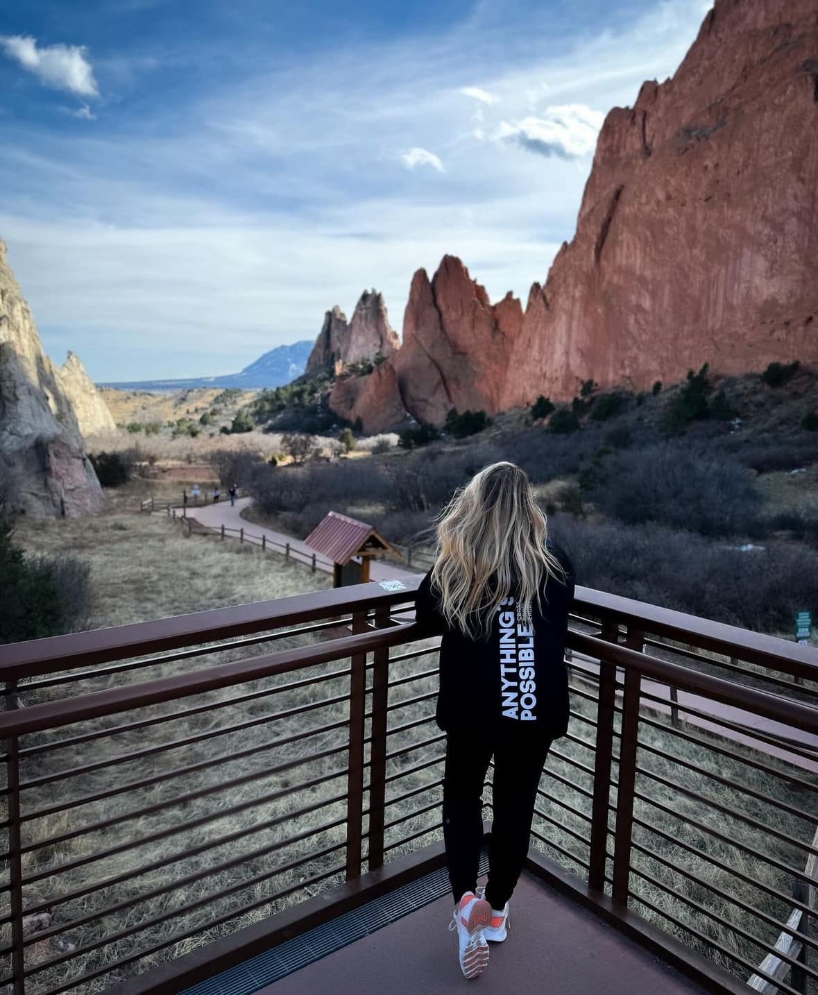 Advisor posing for an image on an outside balcony in the desert with large mountain scapes in the distance during dusk. 