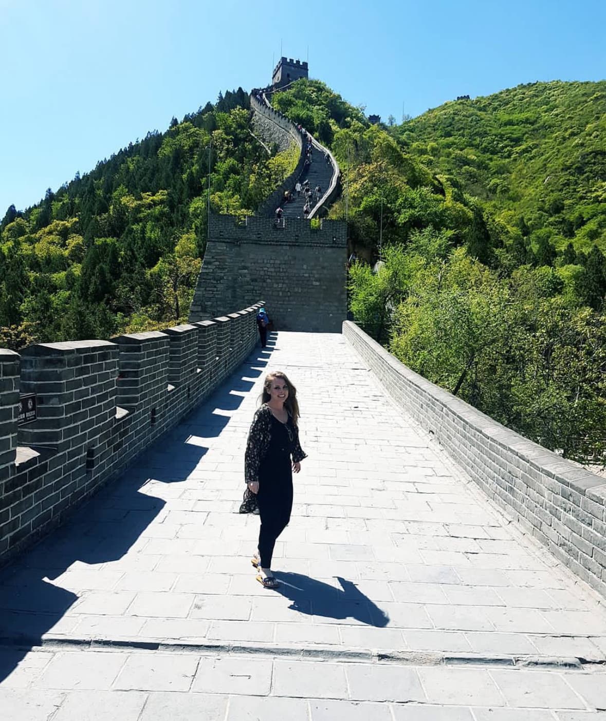 Advisor posing for an image on the Great Wall of China on a sunny day. 