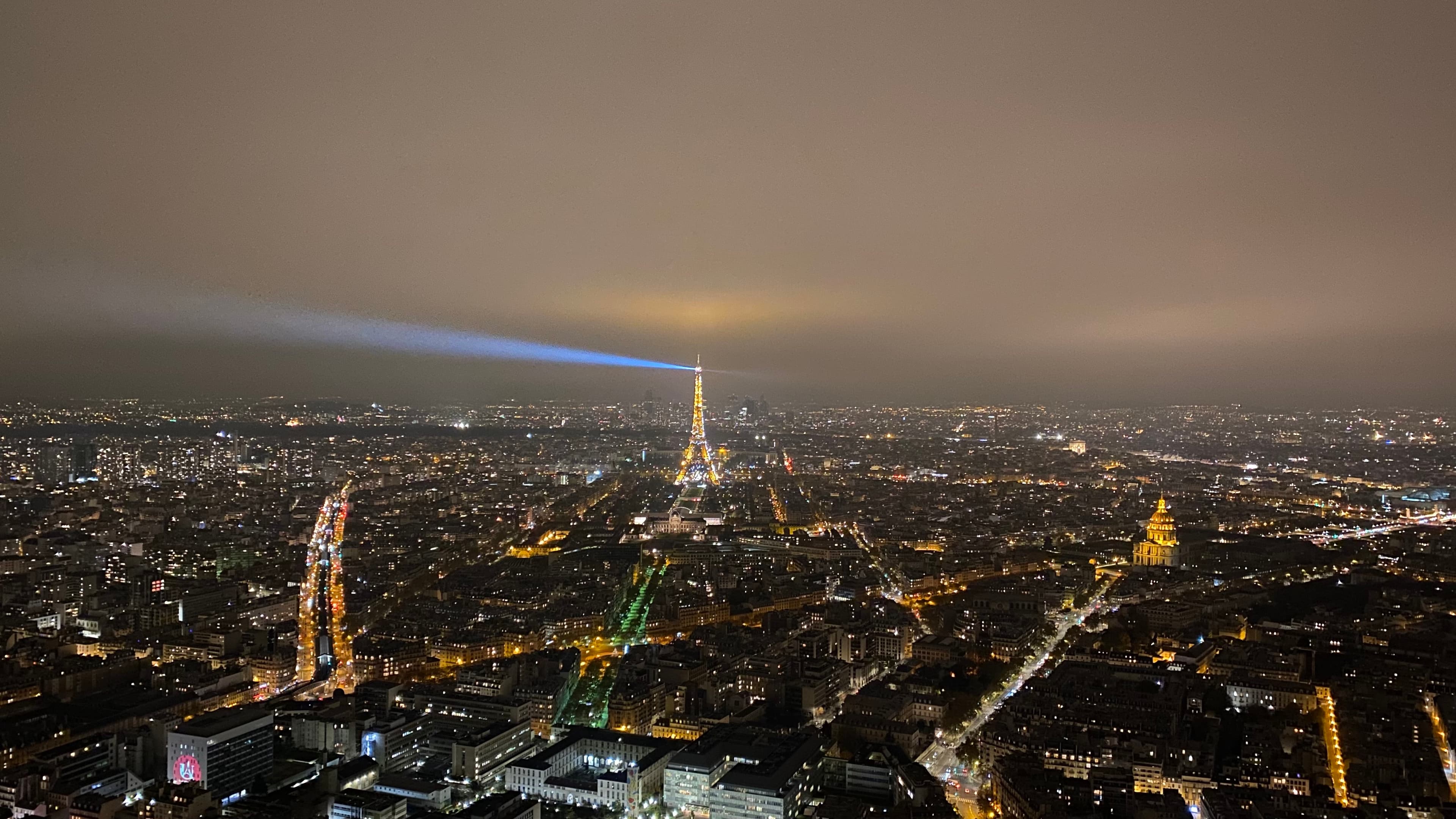 A aerial view of Paris at night with all the city lights glowing. 