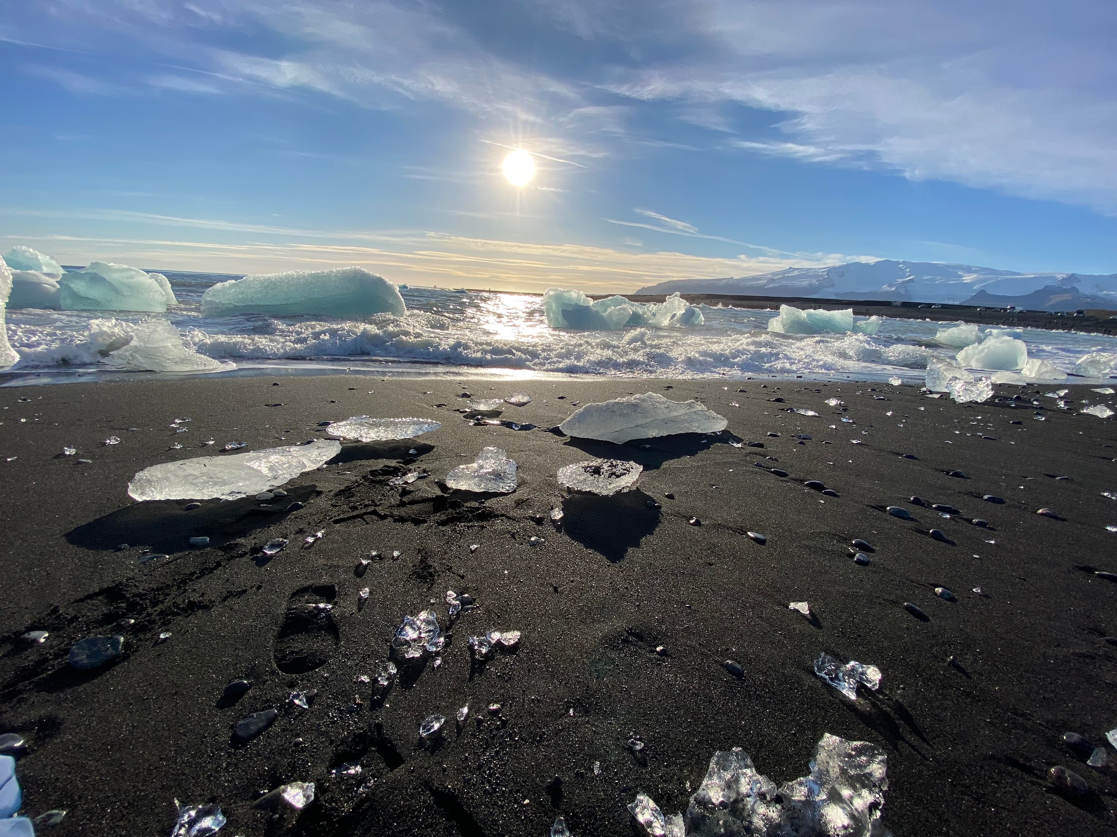 An image of a cold region on a sunny day with icebergs in the distance. 