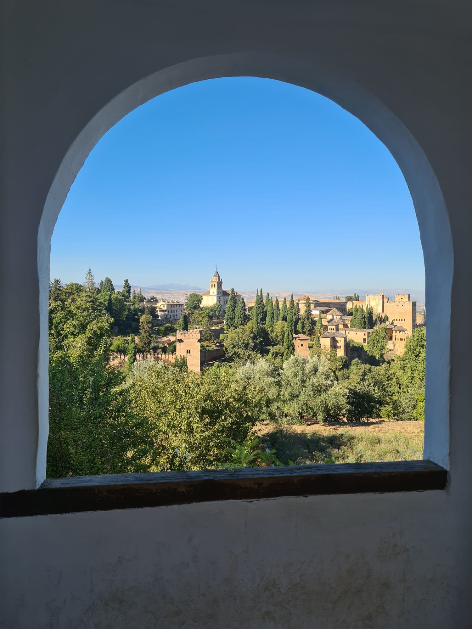 A view of a city through an archway on a sunny day.