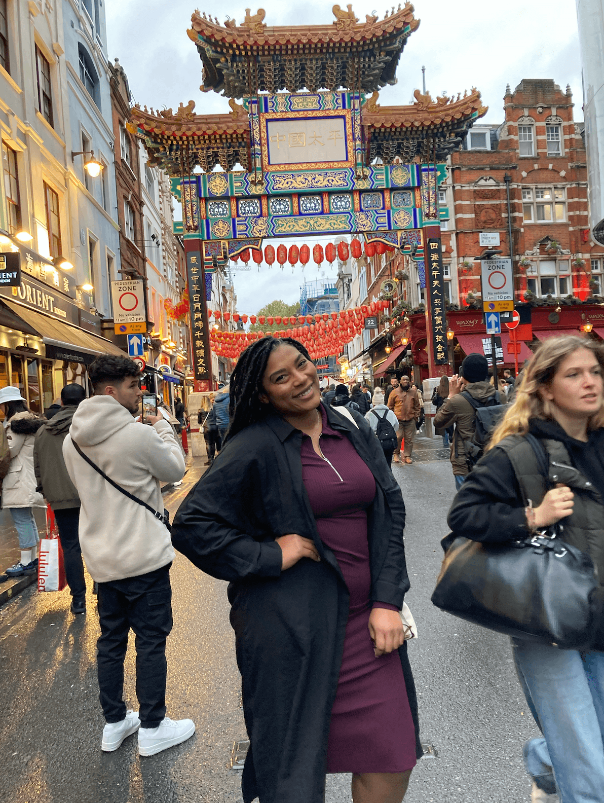 Advisor posing for an image with a colorful background and many people in the street on a sunny day. 