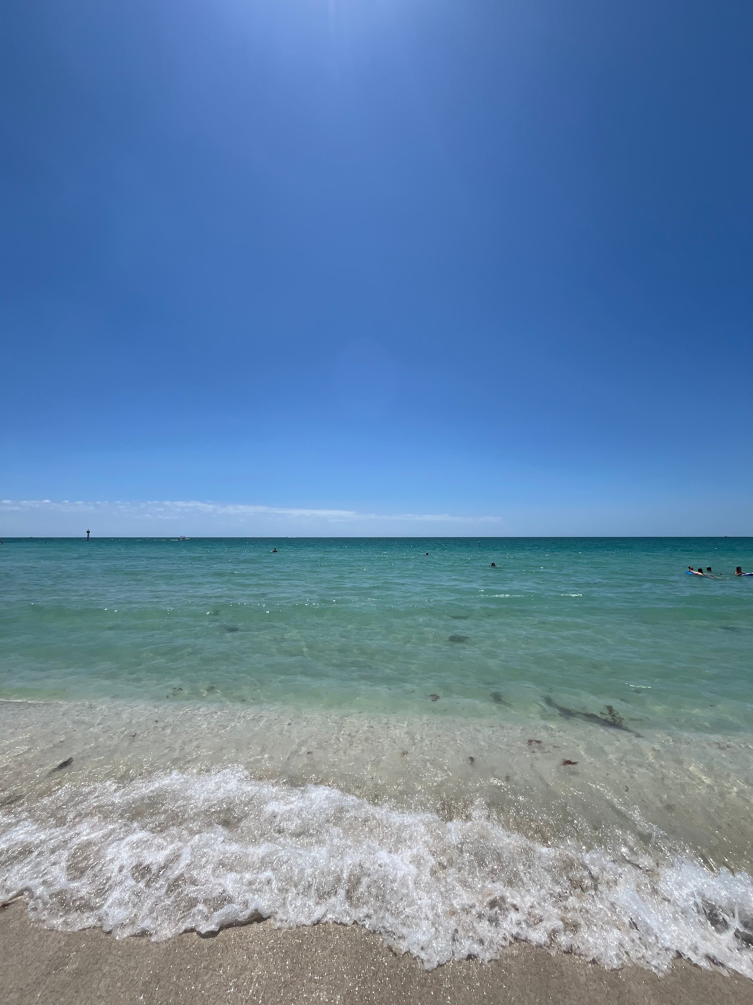 View of a calm sea with waves breaking on shore on a sunny day