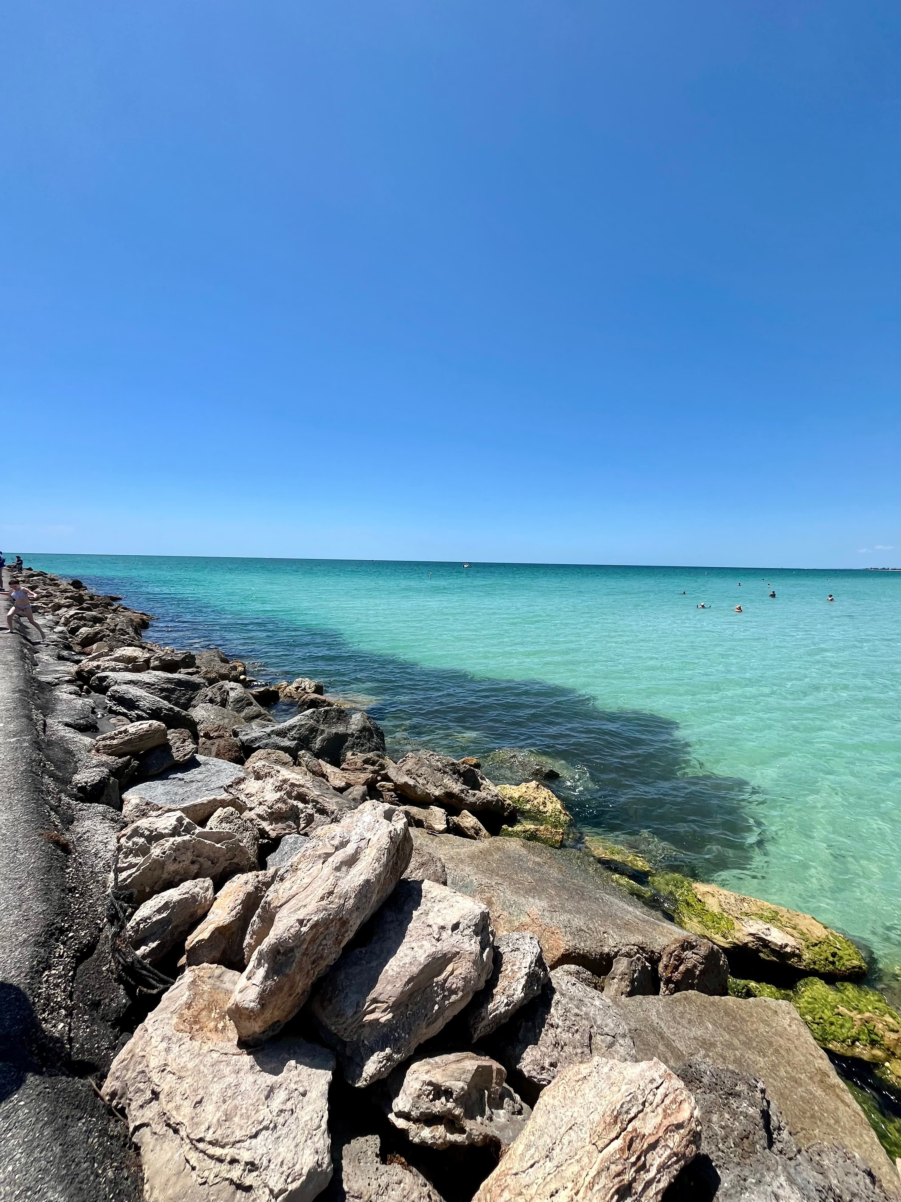 Pretty view of a turquoise sea along a rocky shore under blue skies