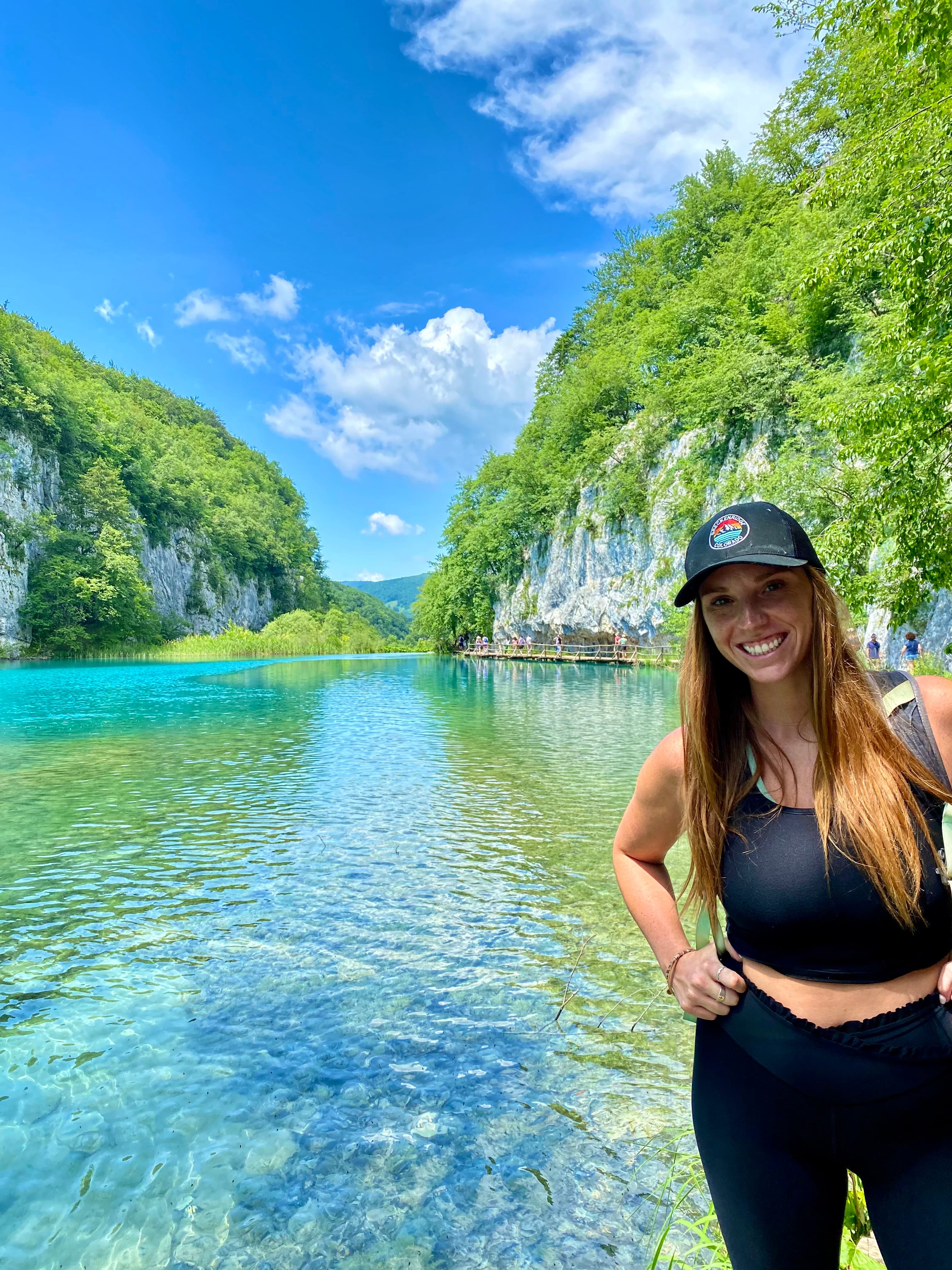 Advisor posing for a photo with a river and foliage in the distance. 
