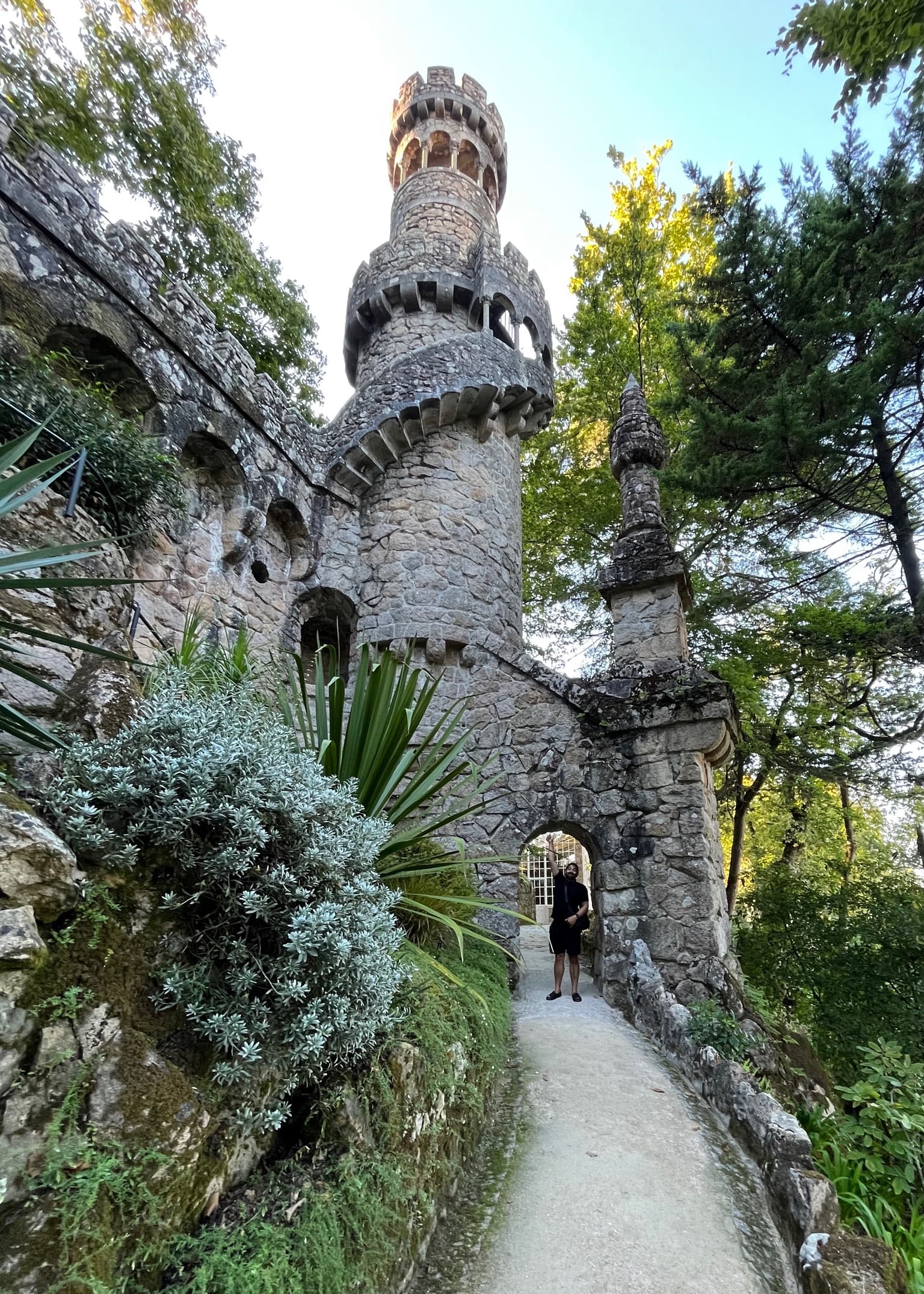 A tall ancient stone structure and tower in a jungle setting.