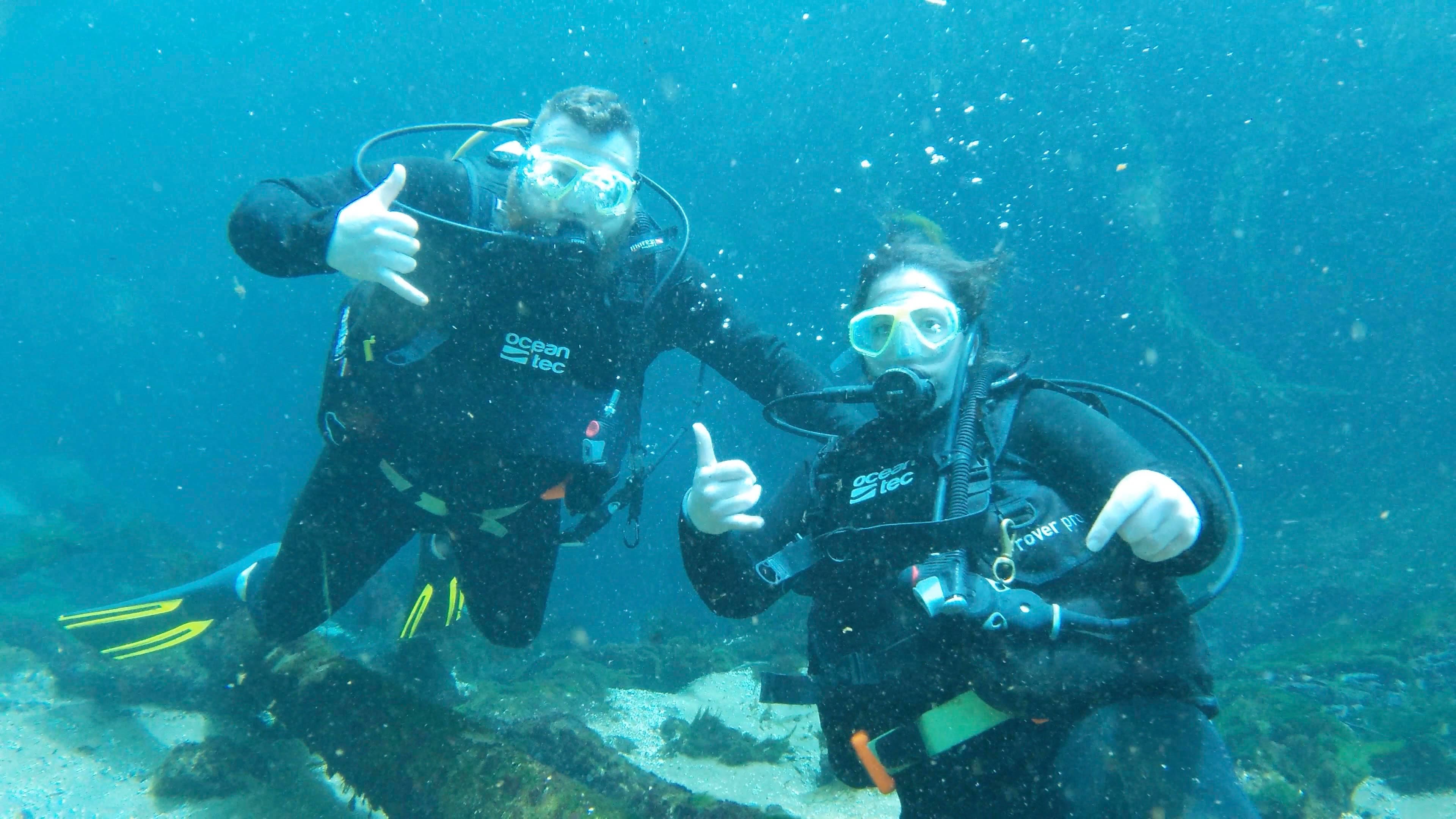Advisor posing underwater in snorkeling gear surrounded by clear blue water and sea life. 