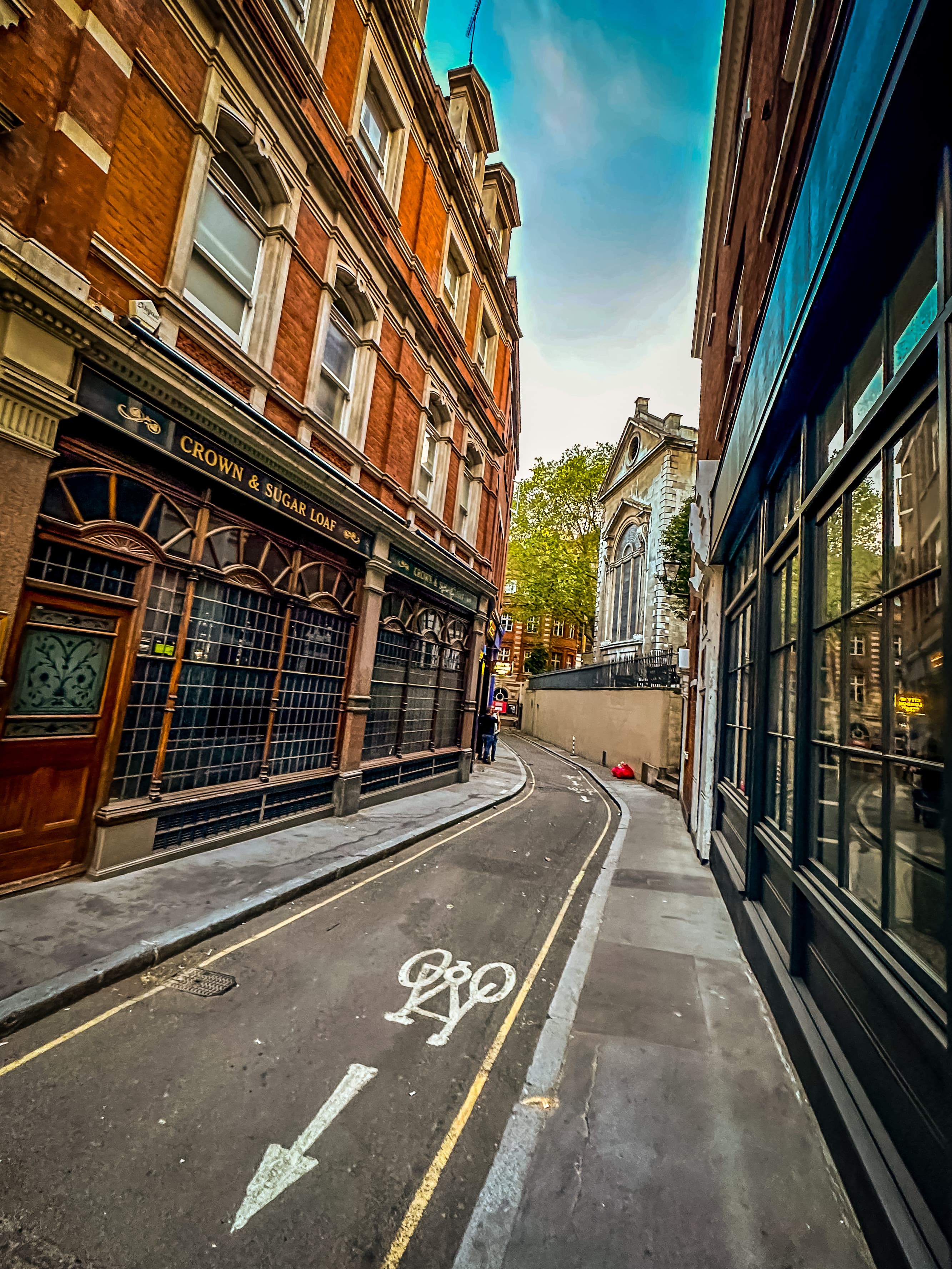 View of an empty narrow road in between picturesque buildings on a sunny day