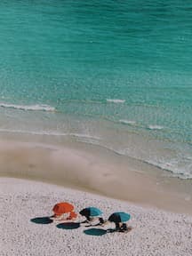 Three umbrellas on the beach during the daytime.