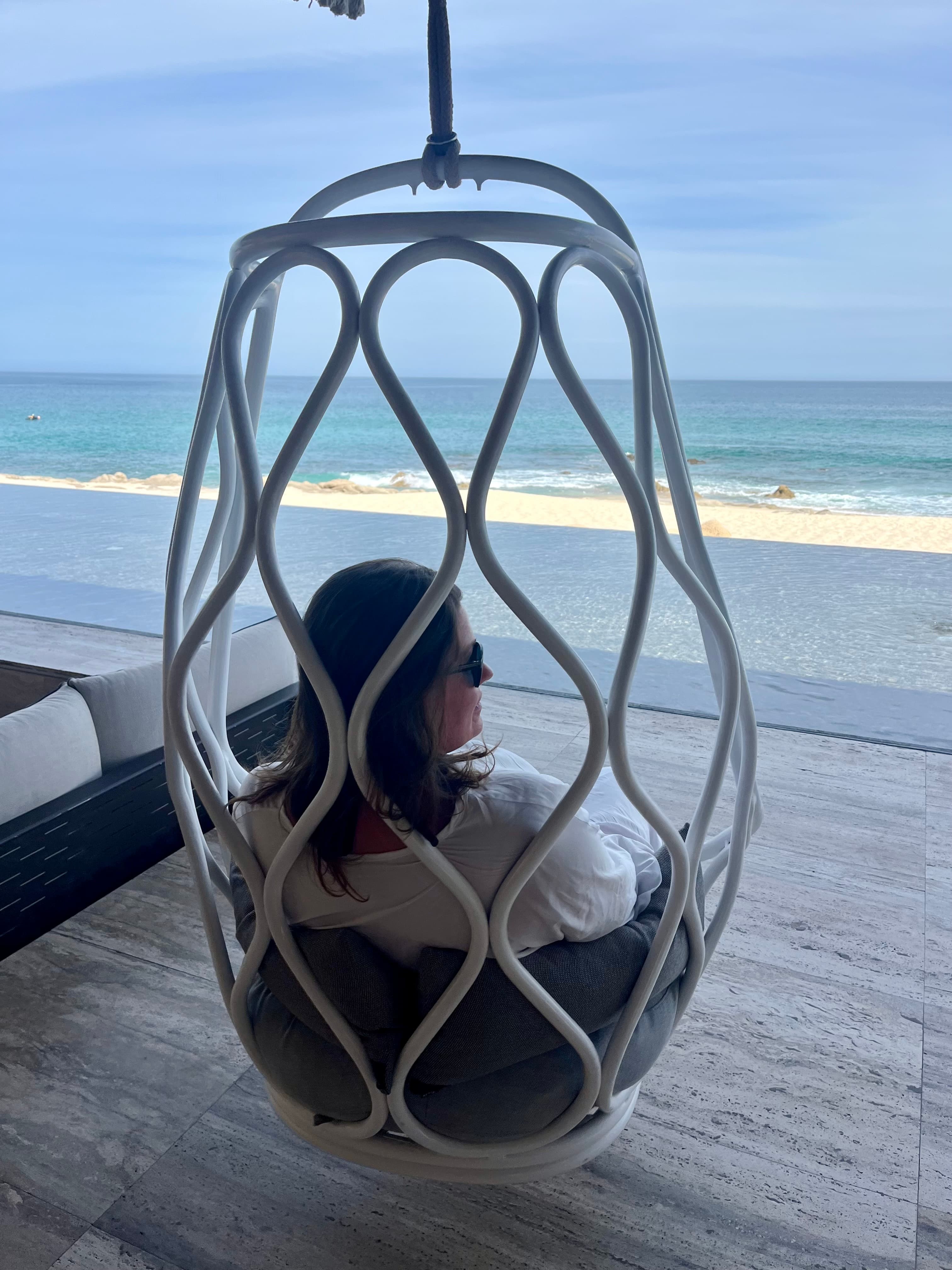 Advisor sitting in an egg shaped chair, looking out towards the beach.