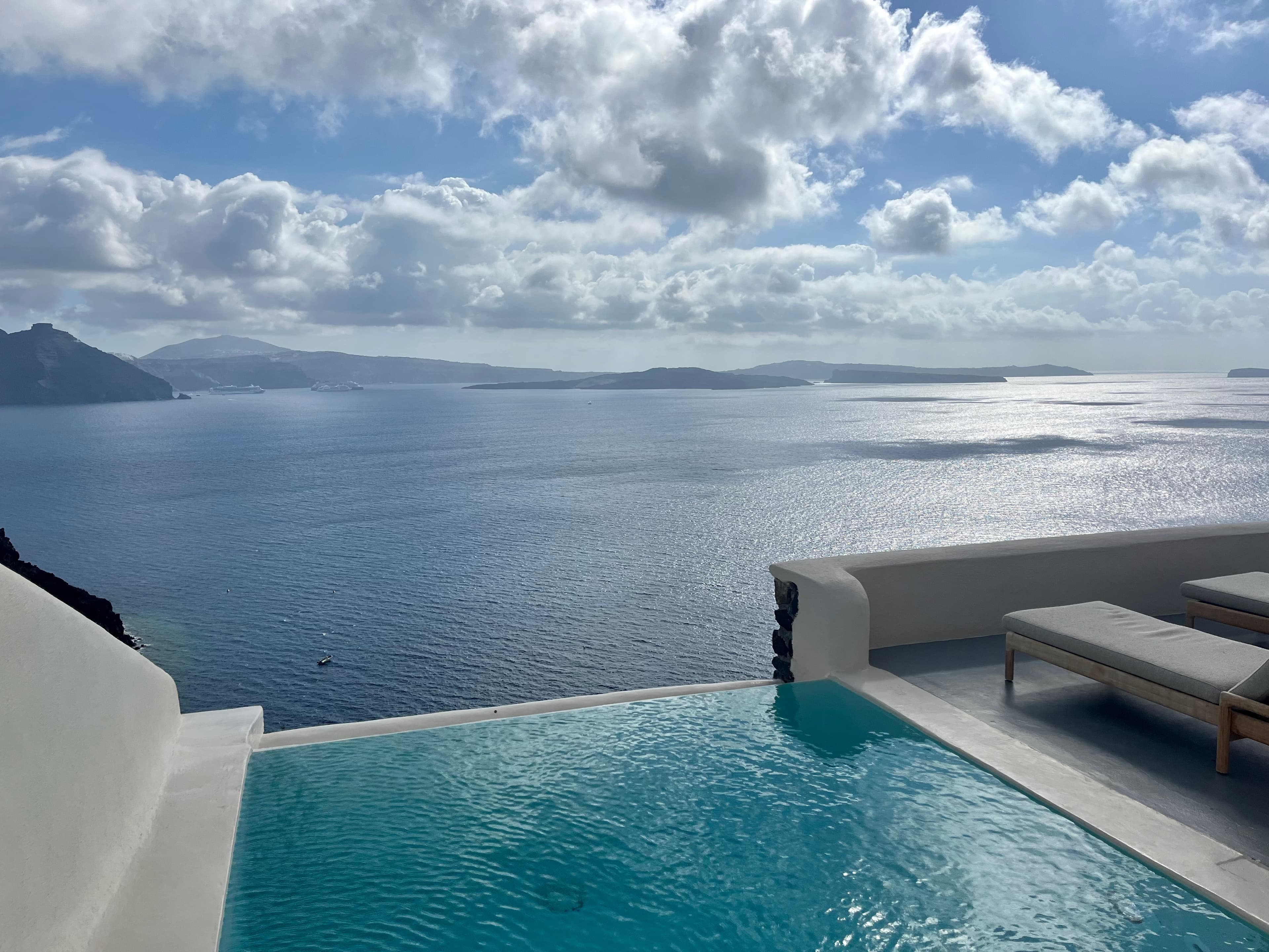 View of a pool with the ocean in the background during the daytime.