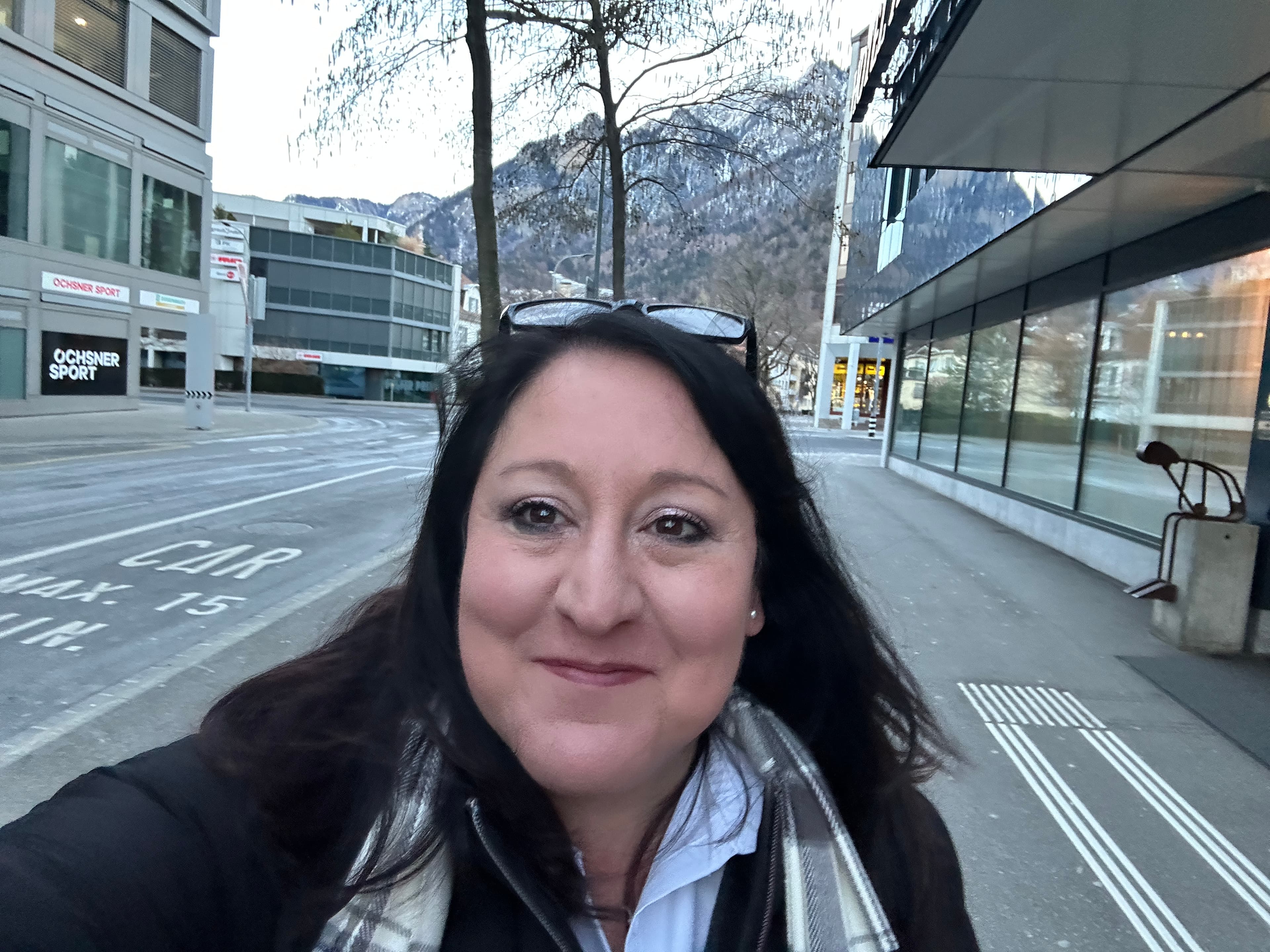 A selfie with a city and mountain in the background. 
