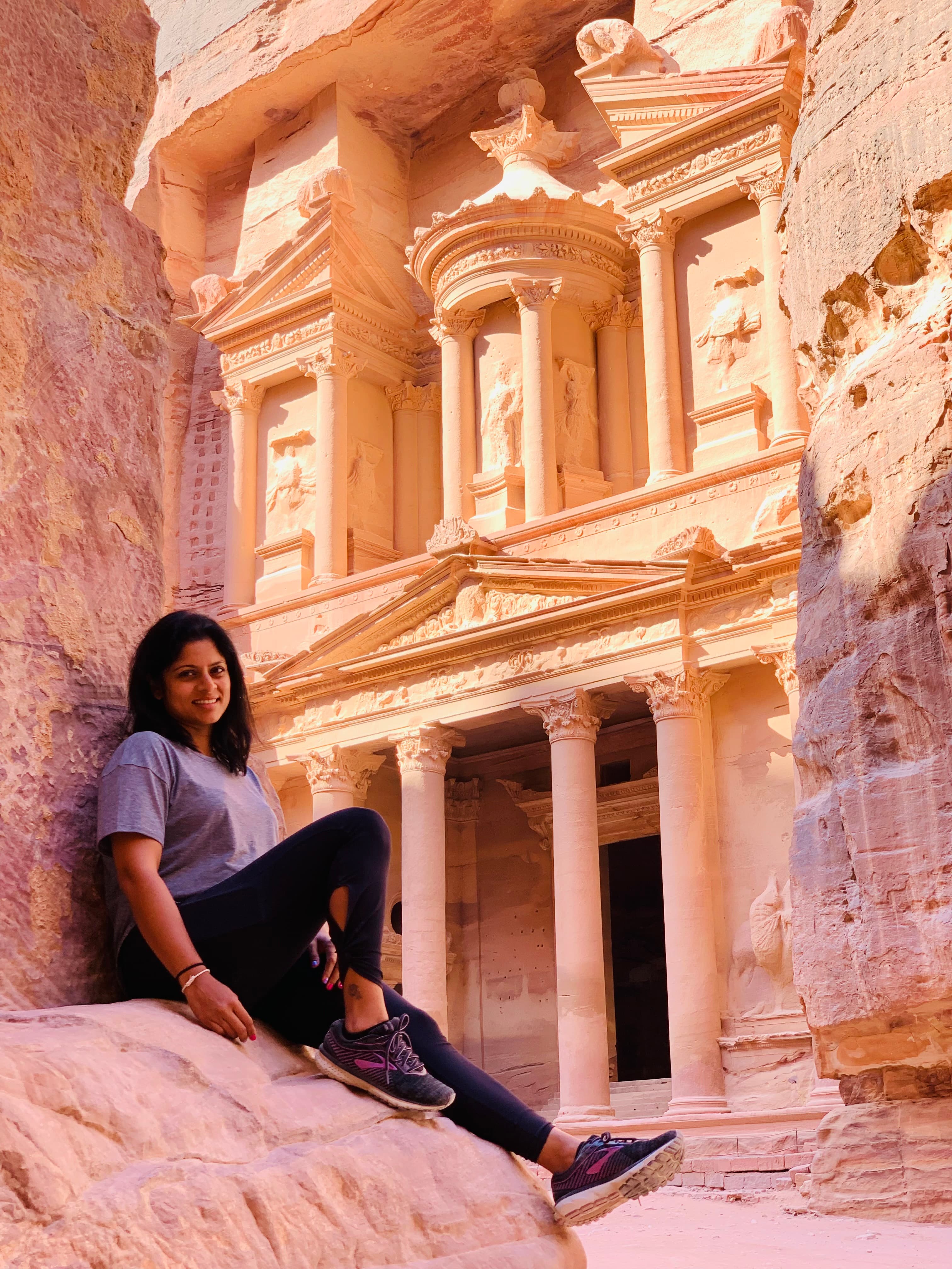 Photo of advisor sitting against a rock ledge during the daytime.