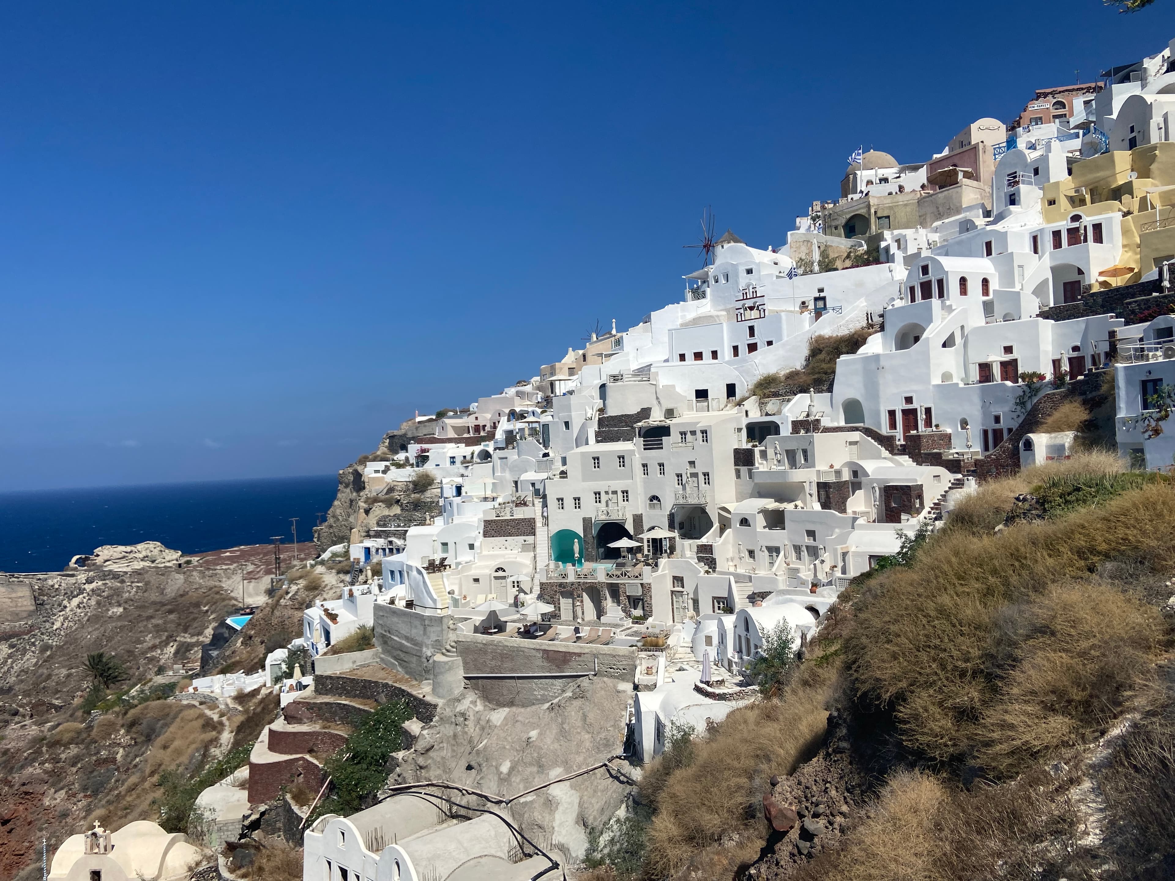 Blue skies over white hill top buildings.