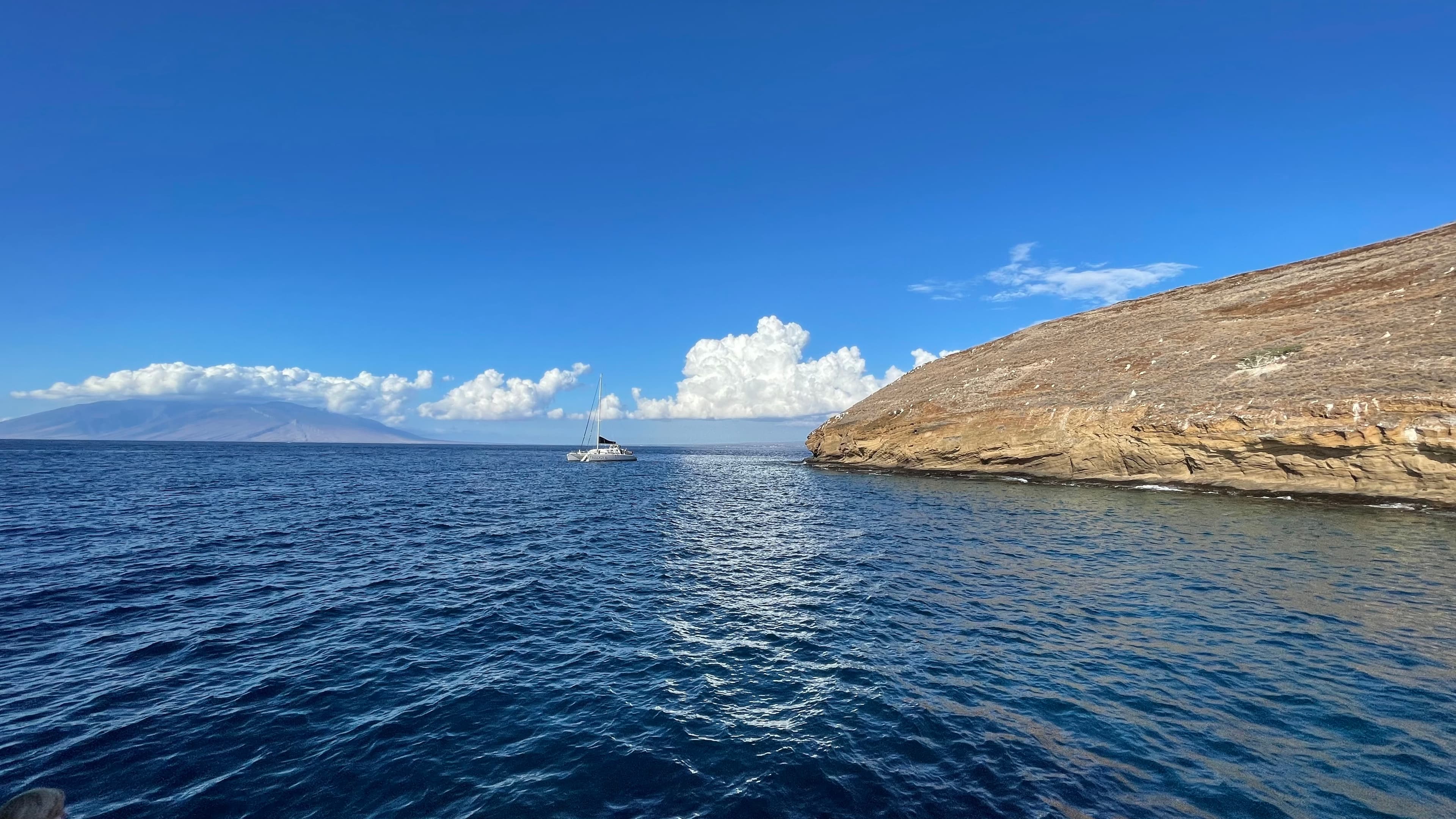 Beautiful view of a calm ocean and rocky coastline under sunny skies