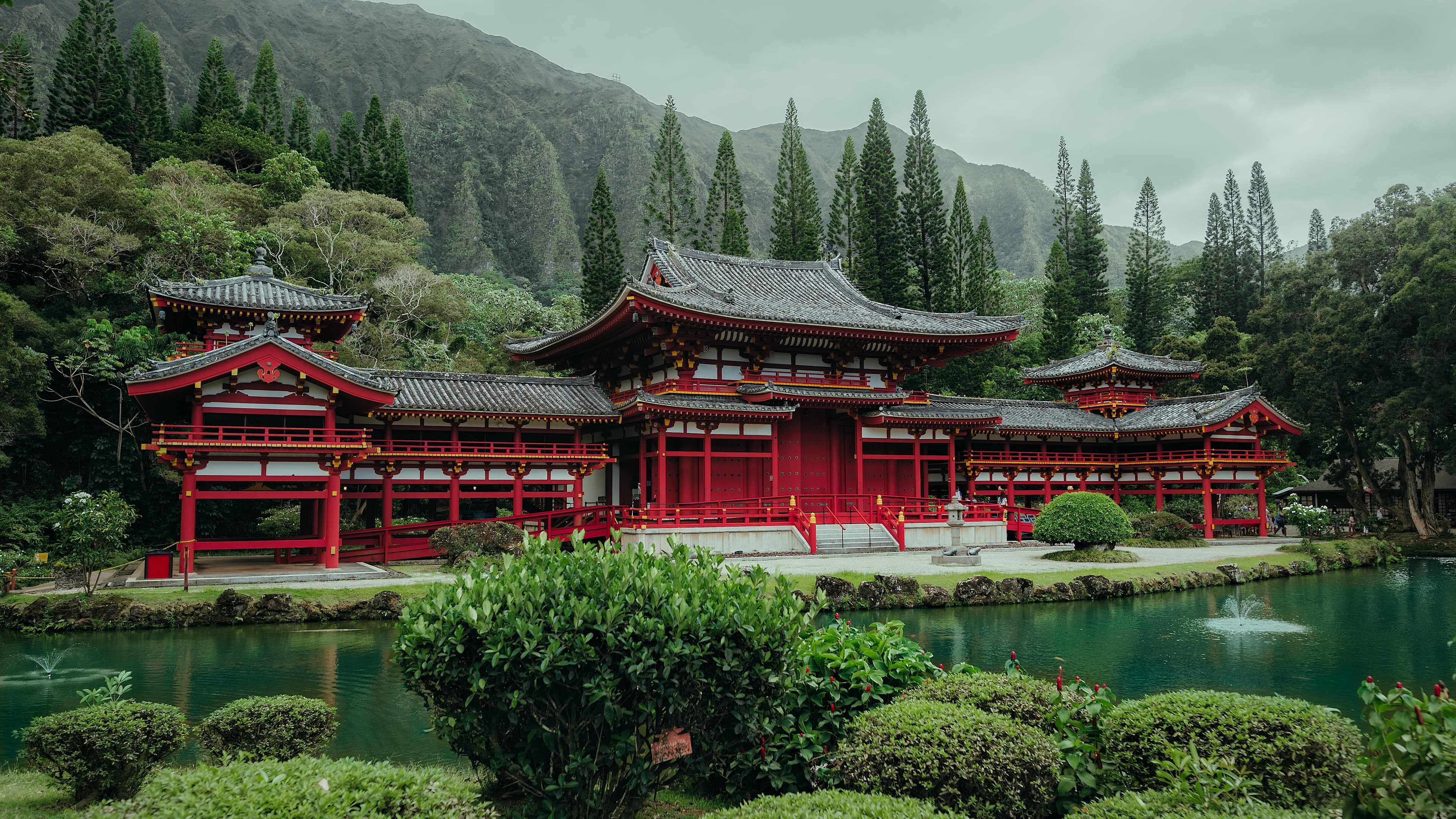 Historic sturctures standing tall among evergreens and mountains on a misty day. 