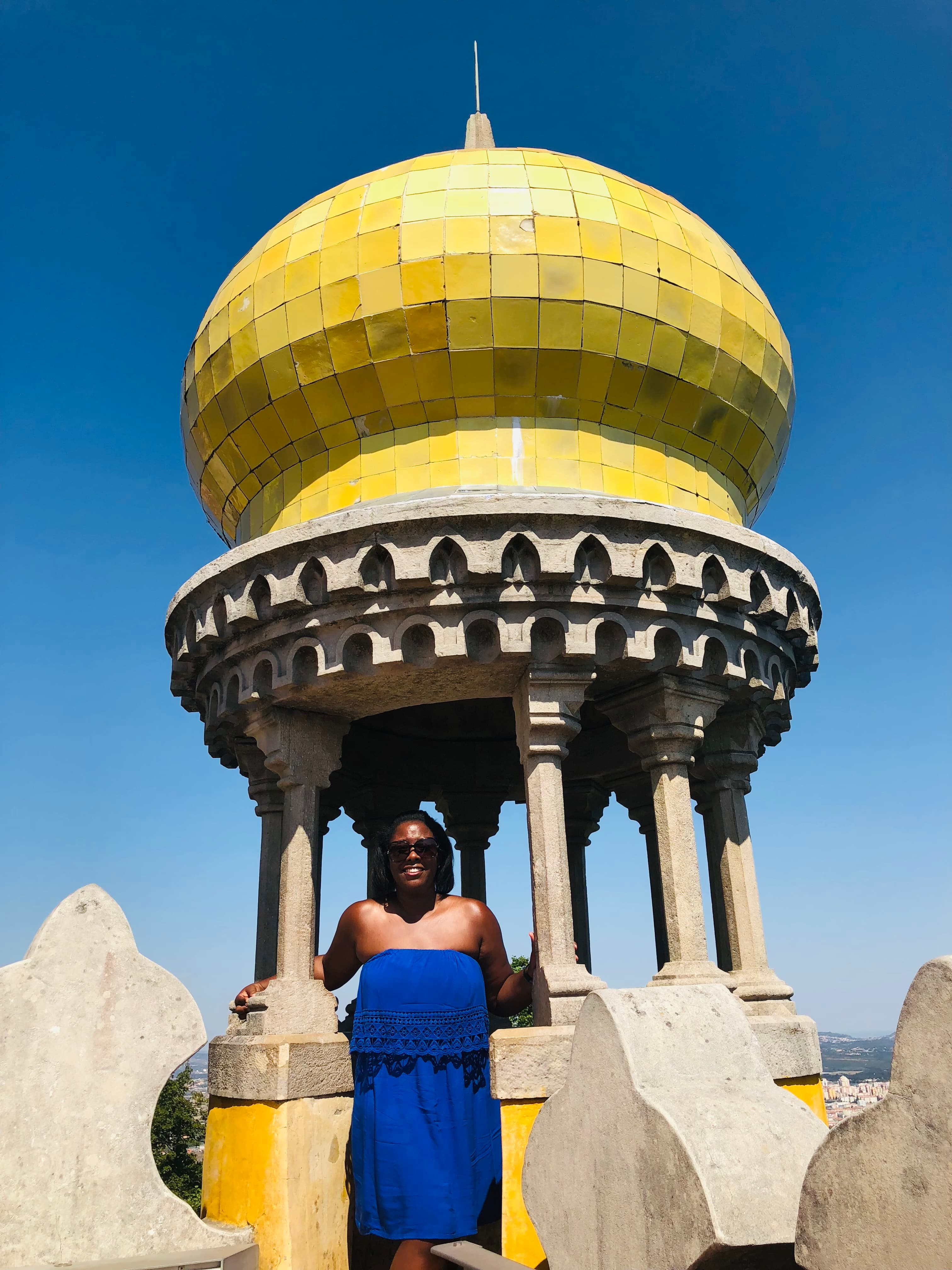 Advisor poses beneath a yellow-tiled structure.
