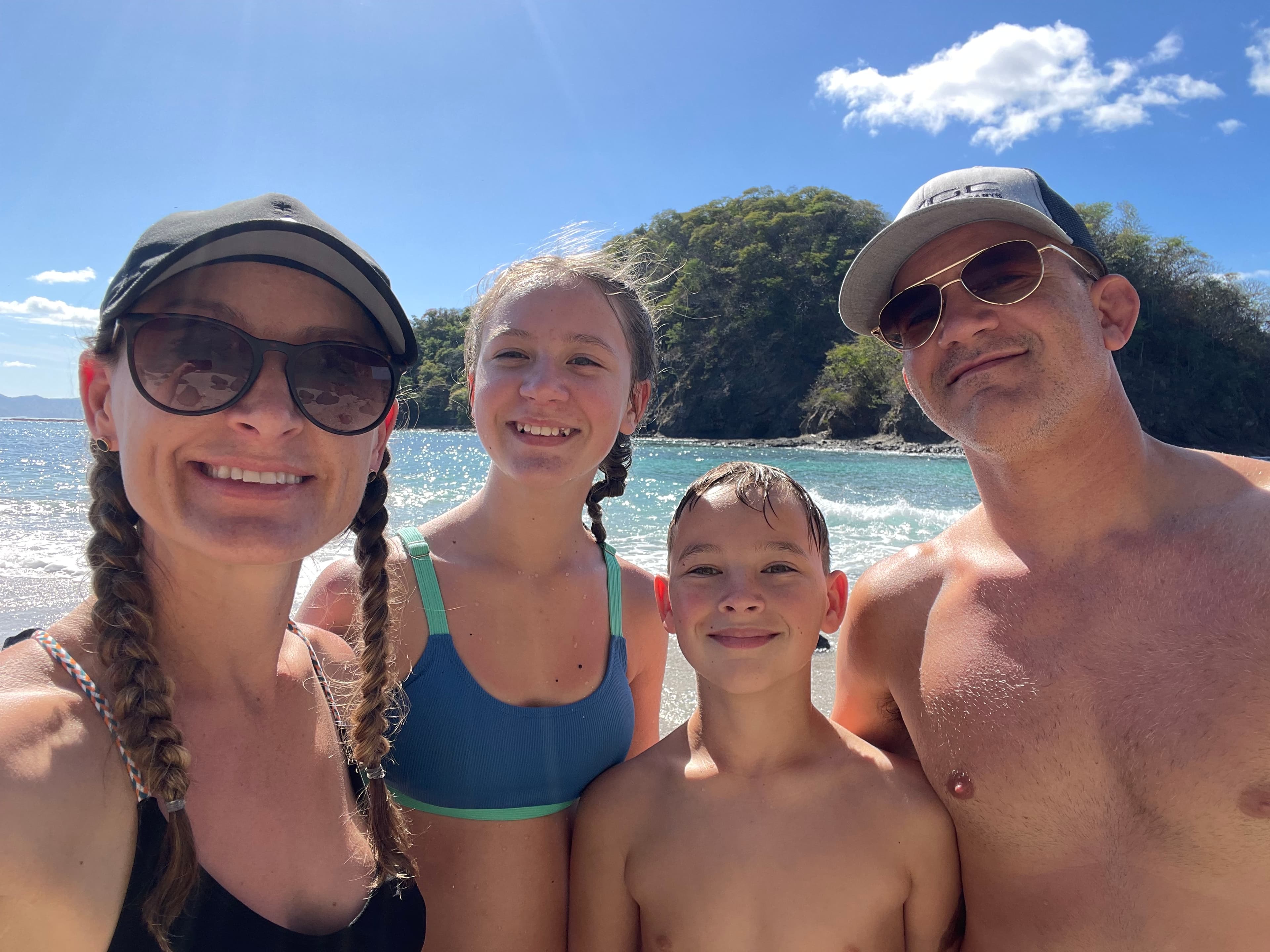 Brie and her family posing for a selfie on a beautiful sunny beach