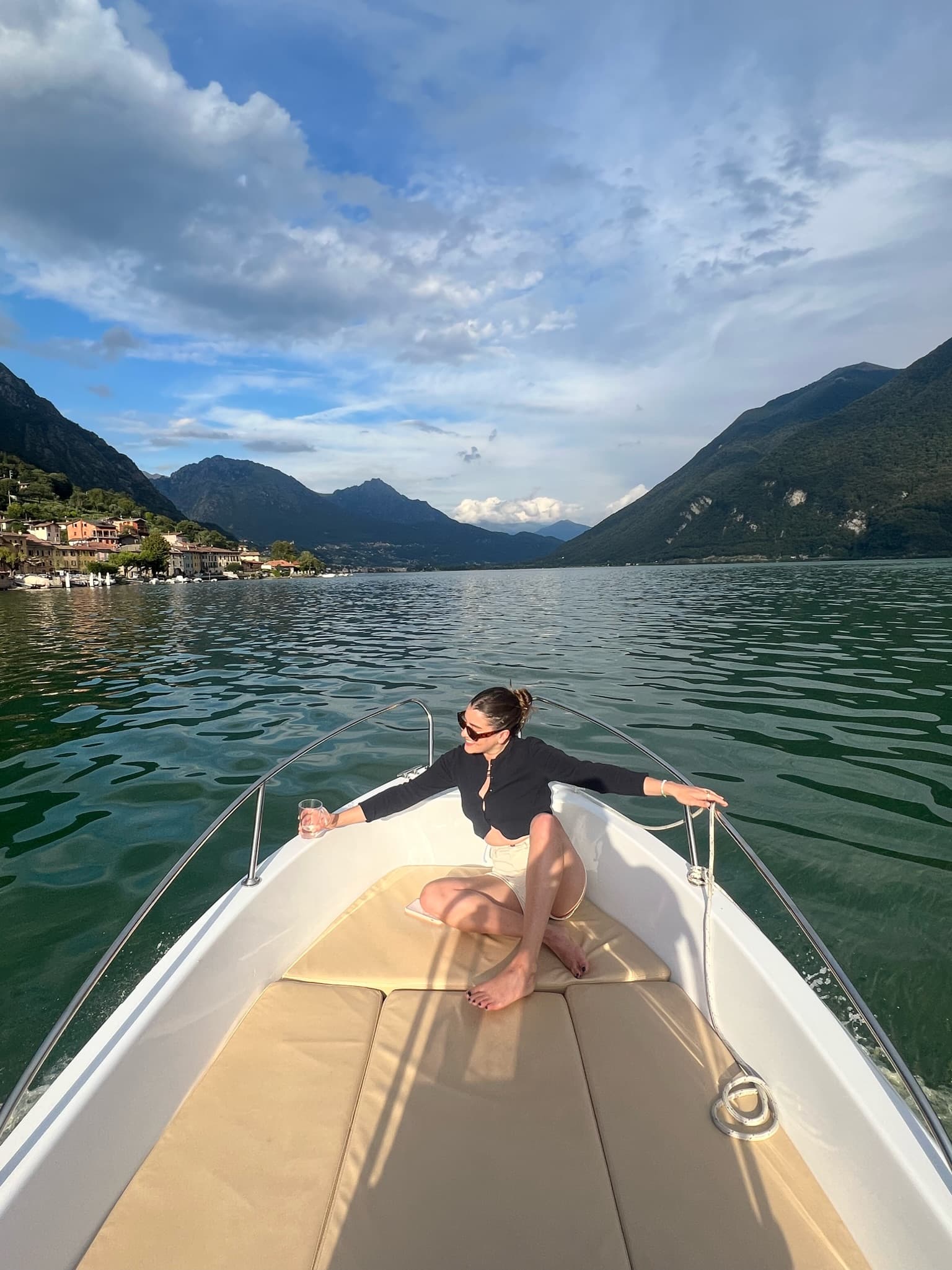 Advisor sitting on a boat in the ocean with mountains in the distance at dusk. 