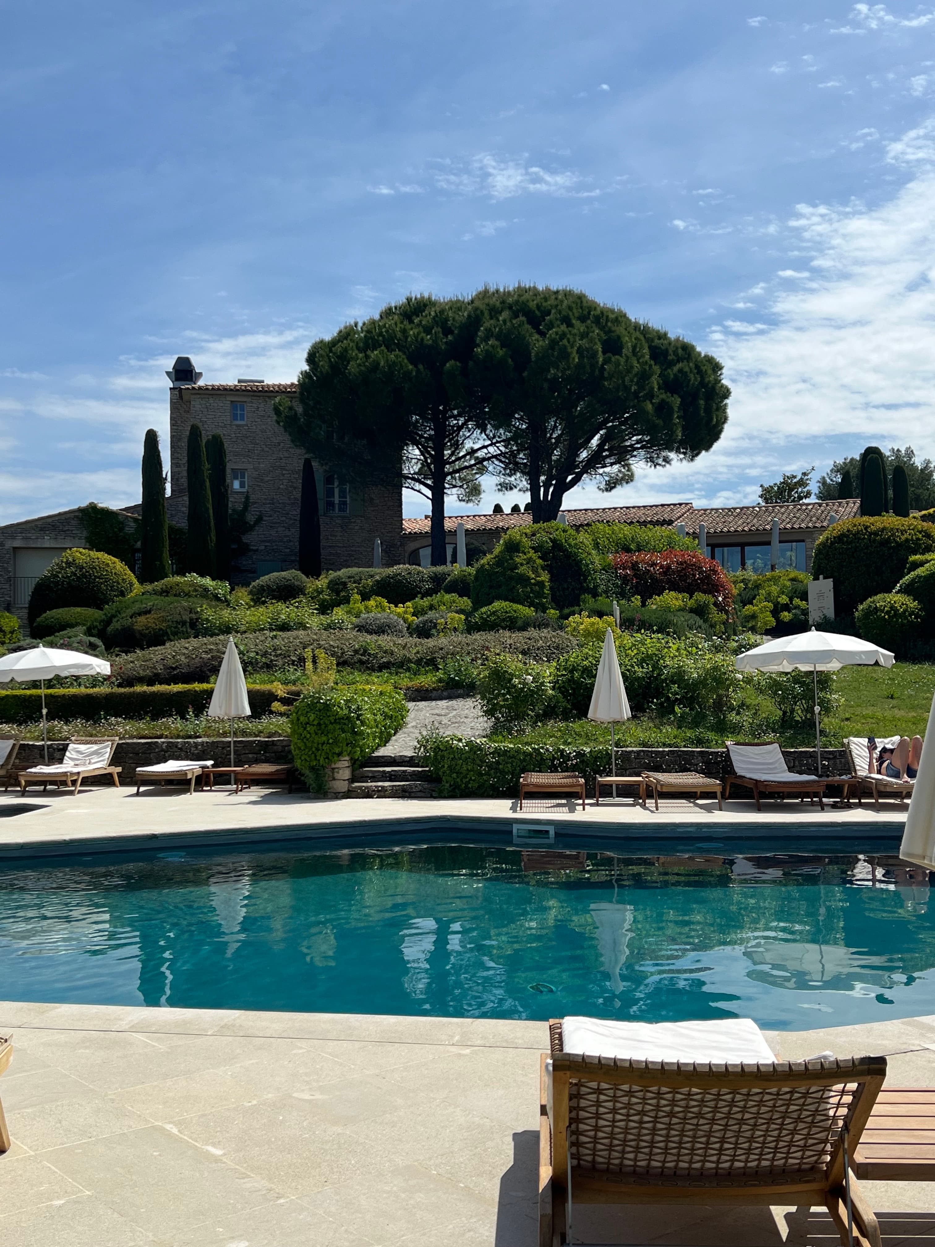 A view of a pool with foliage in the distance during the daytime. 