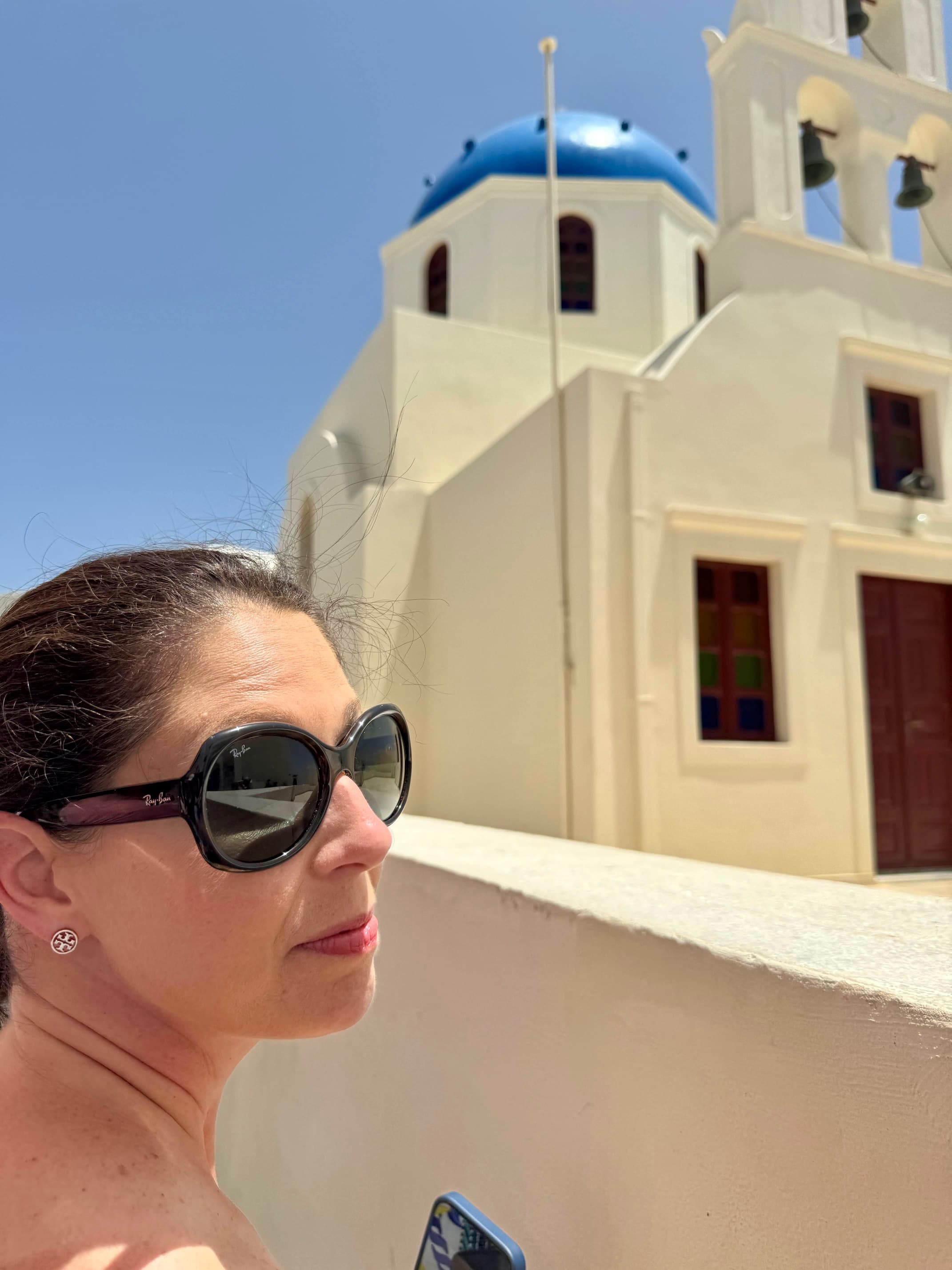 Advisor standing in front of a large white building with a tall blue dome during the day.