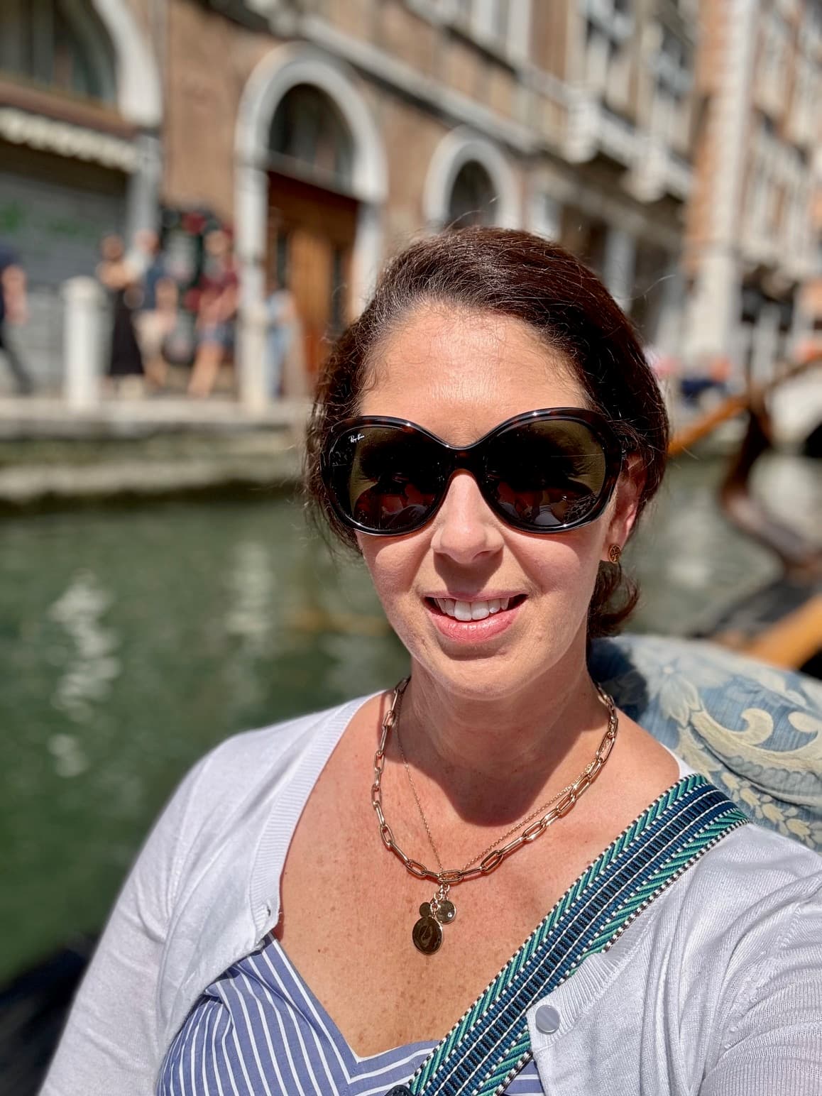 Advisor posing in a boat on a canal lined with buildings.